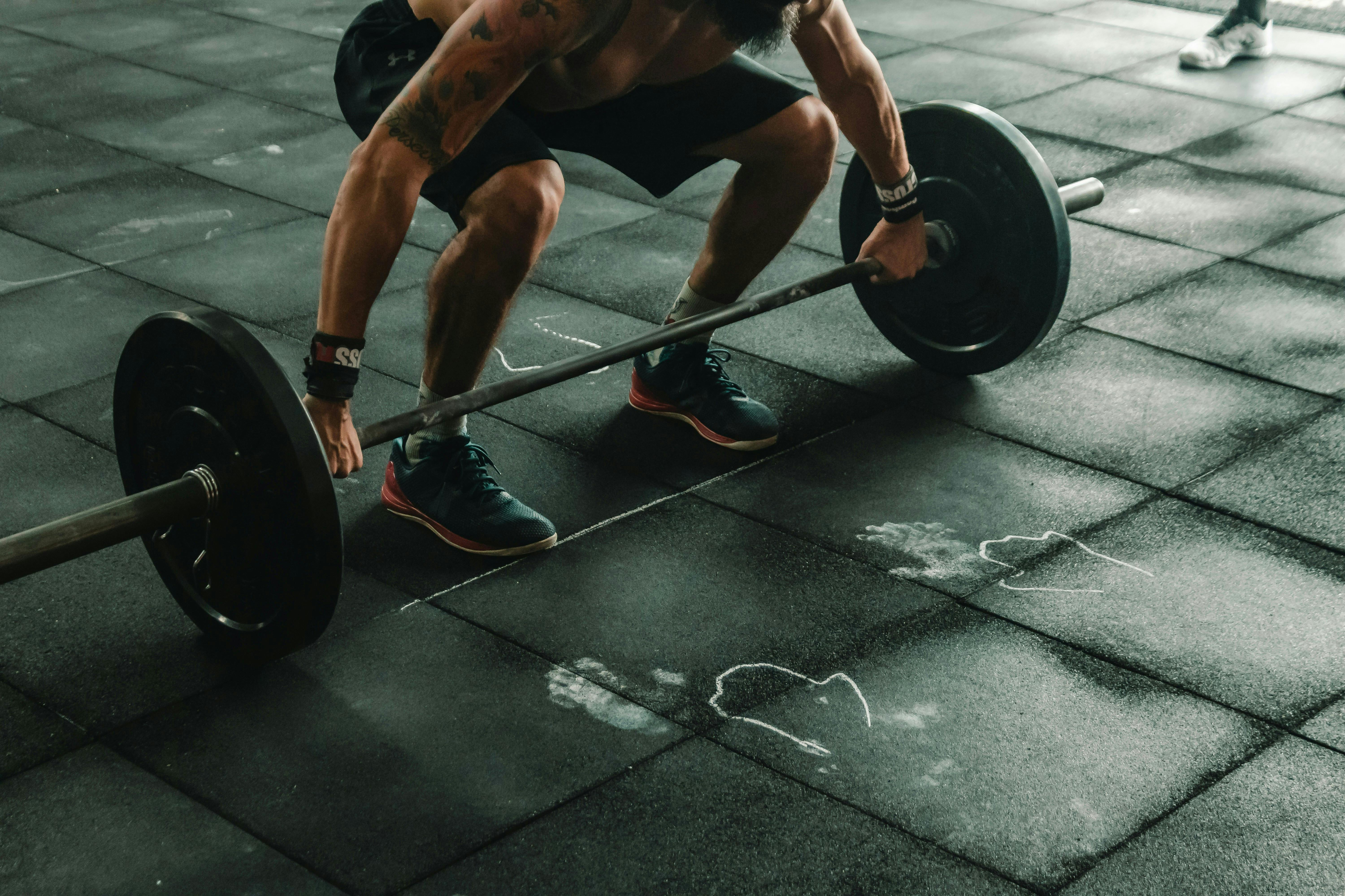 A person about to pick up a barbell at a gym