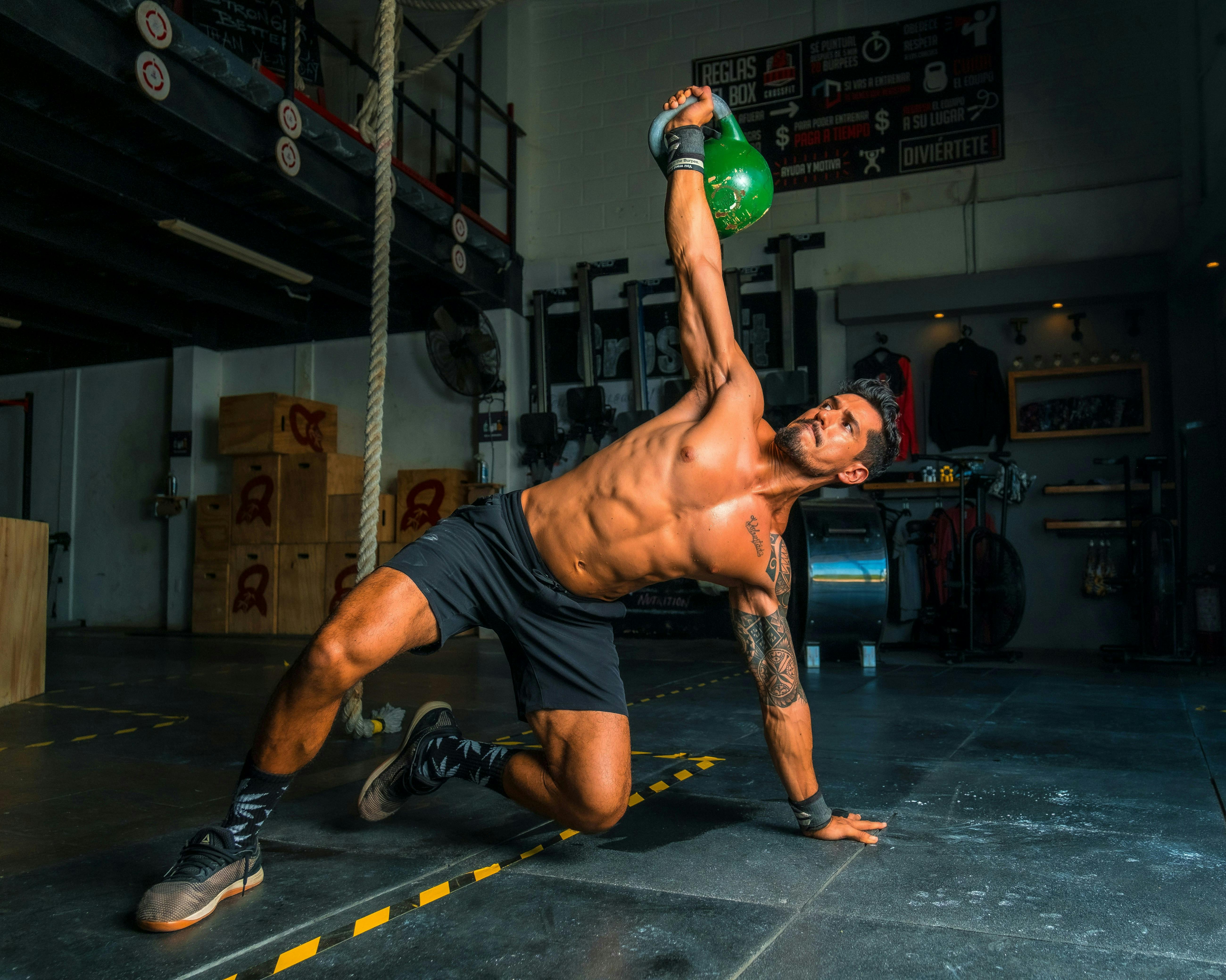 A man holding a kettlebell above his head while doing an exercise