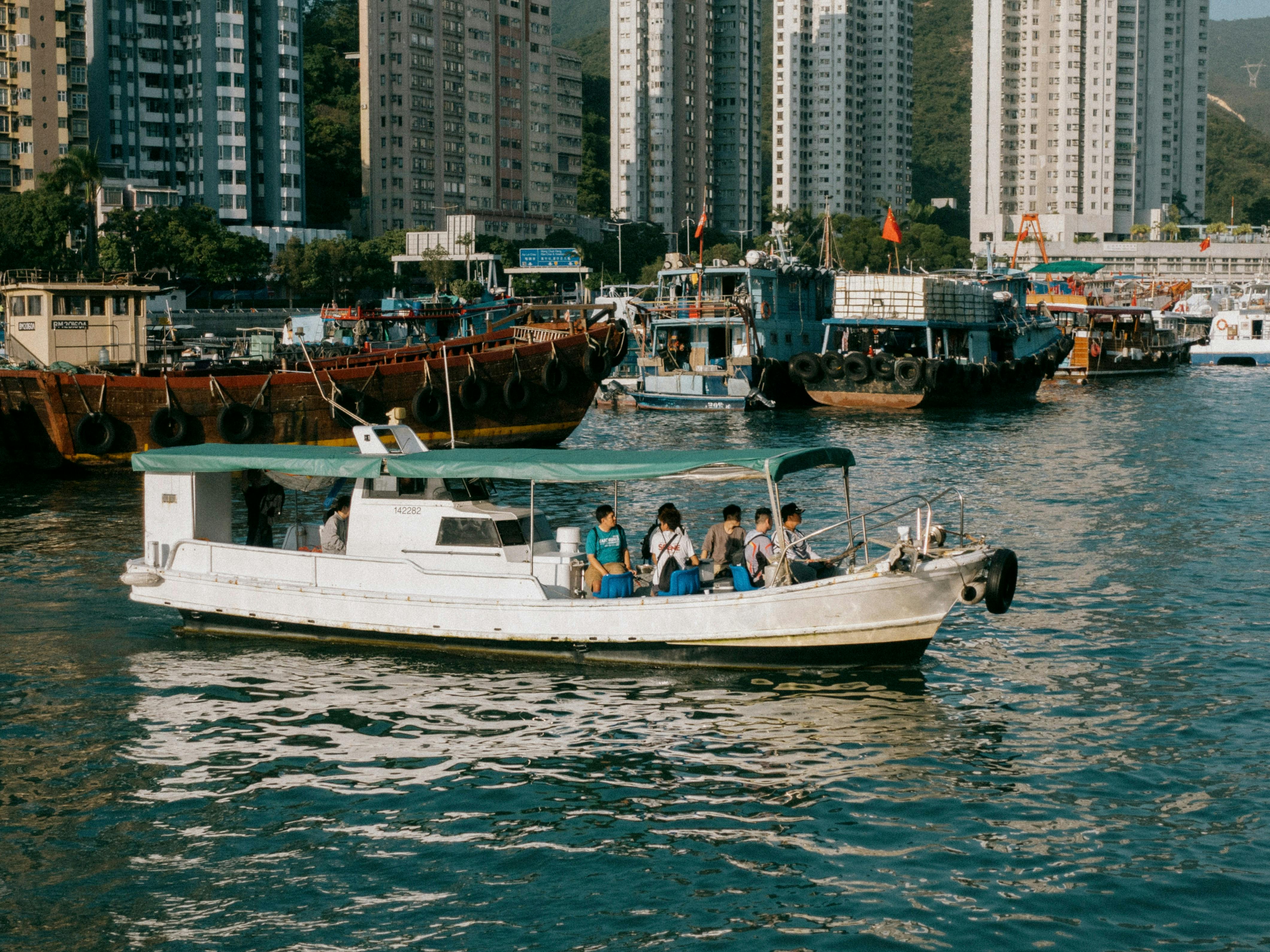 A white boat with a green roof about to float out of a harbor 