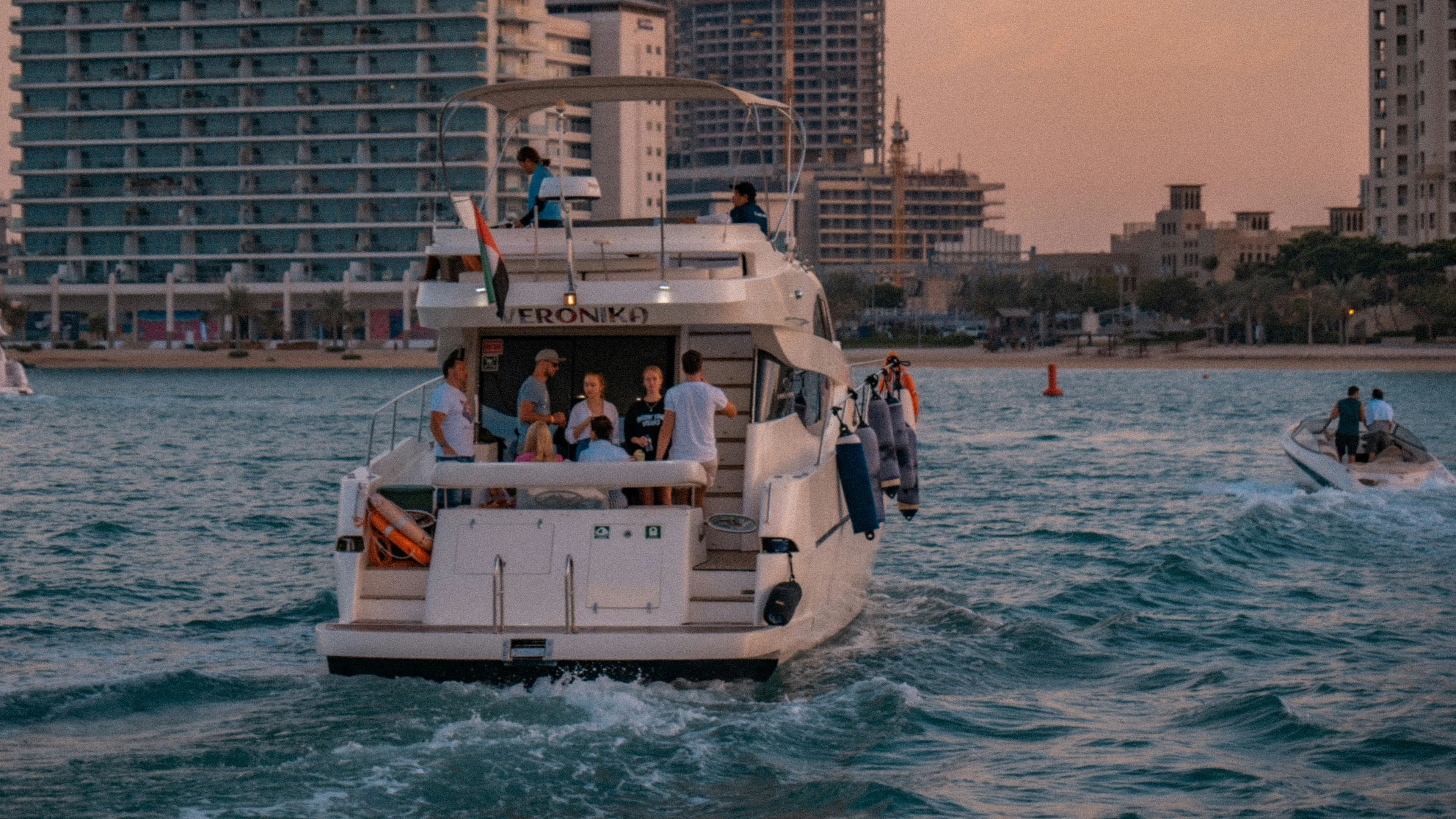 A boat full of people headed back to shore at sunset