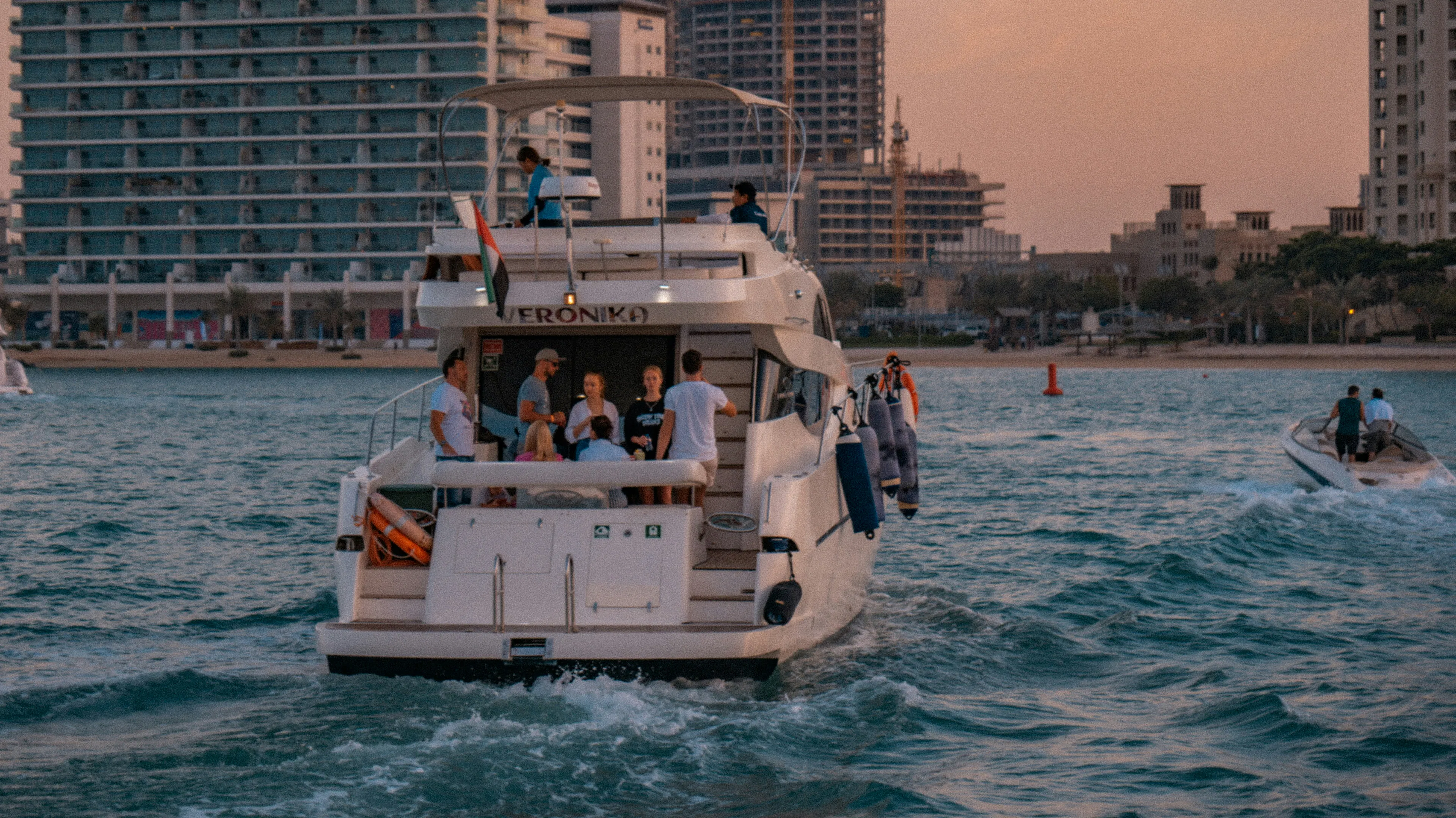 A boat full of people headed back to shore at sunset