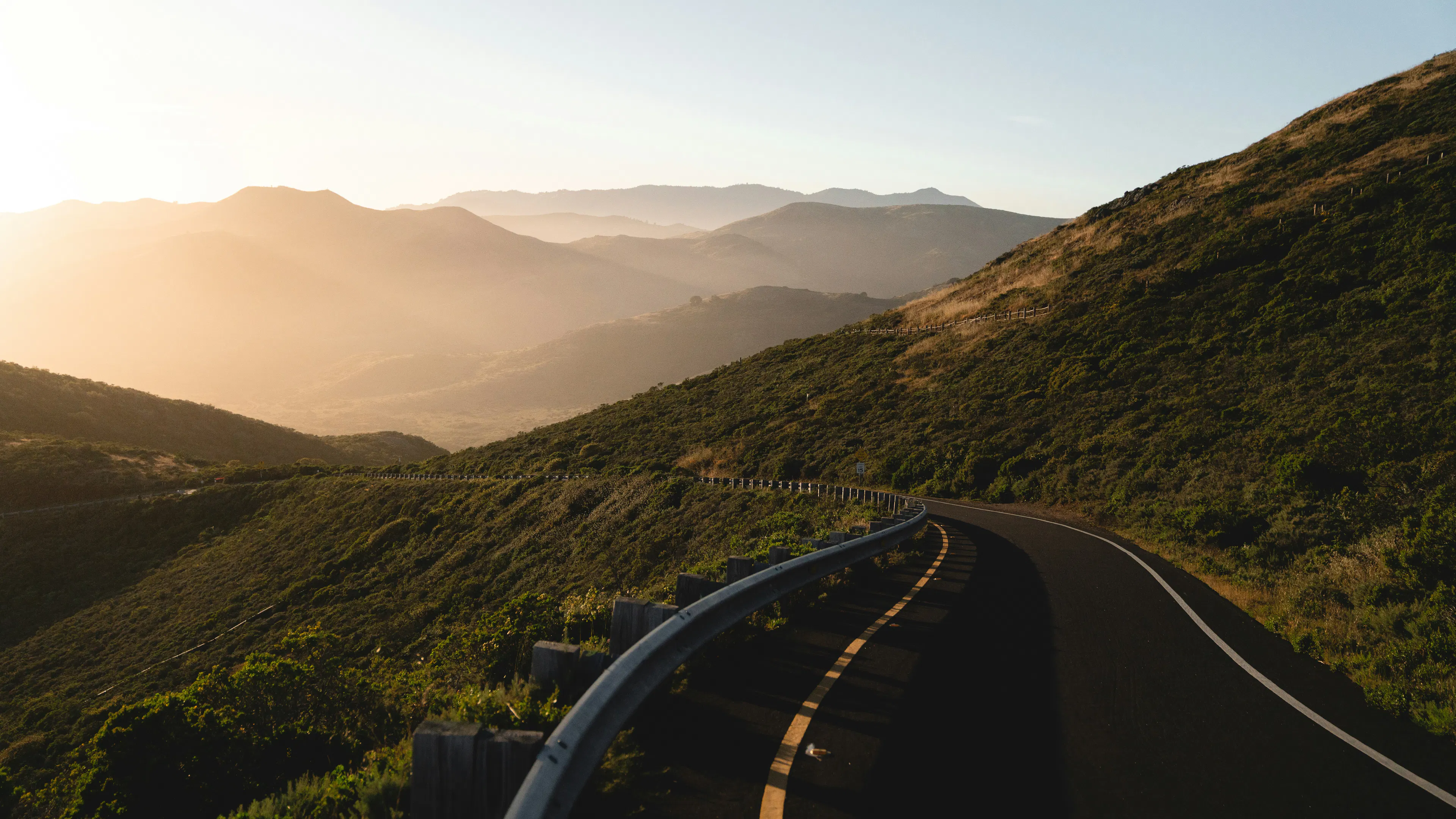 Scenic Route 101 heading down a hillside at sunset through the Marin Headlands