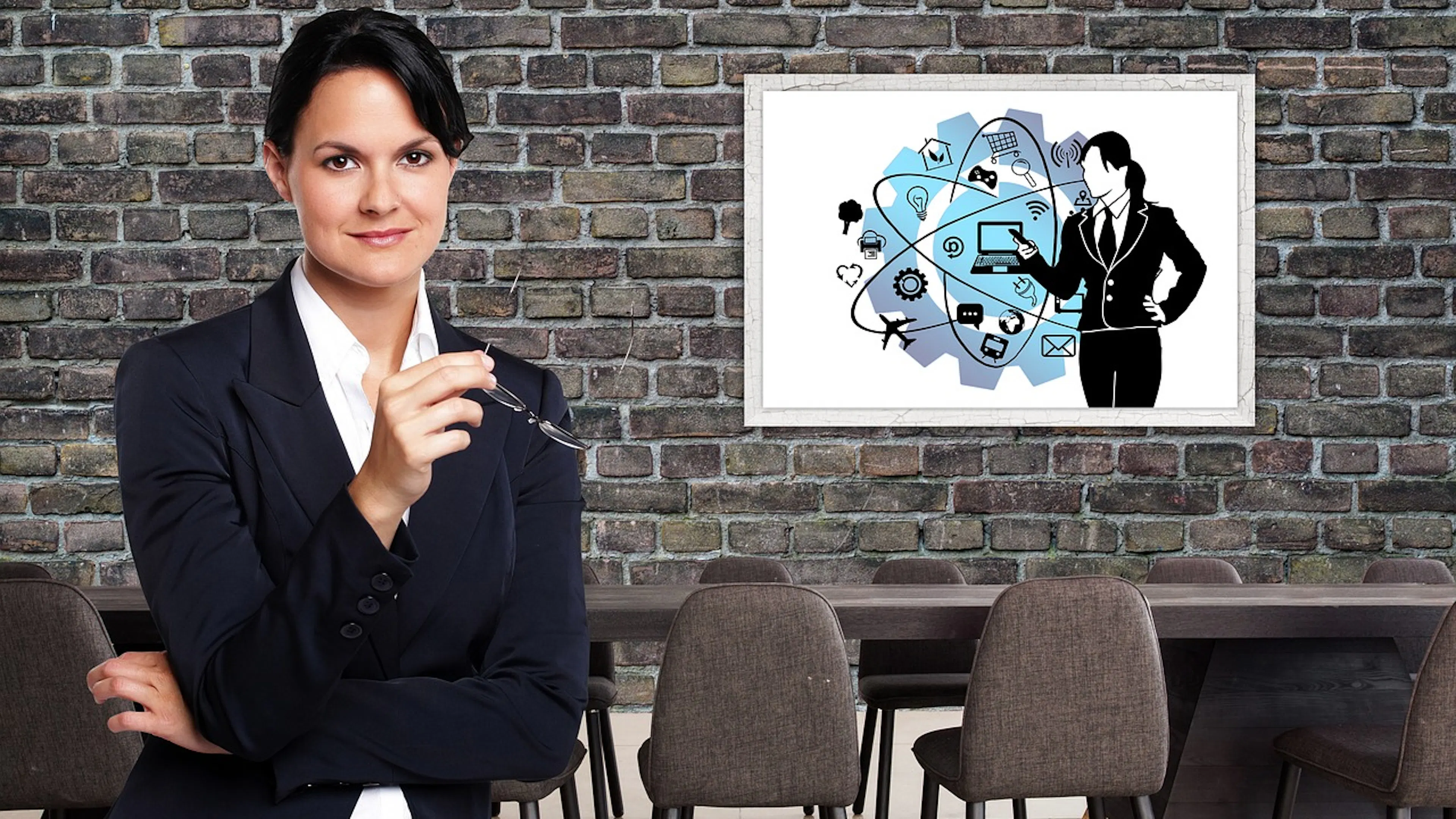 woman in dark suit in front of brick wall with modern art