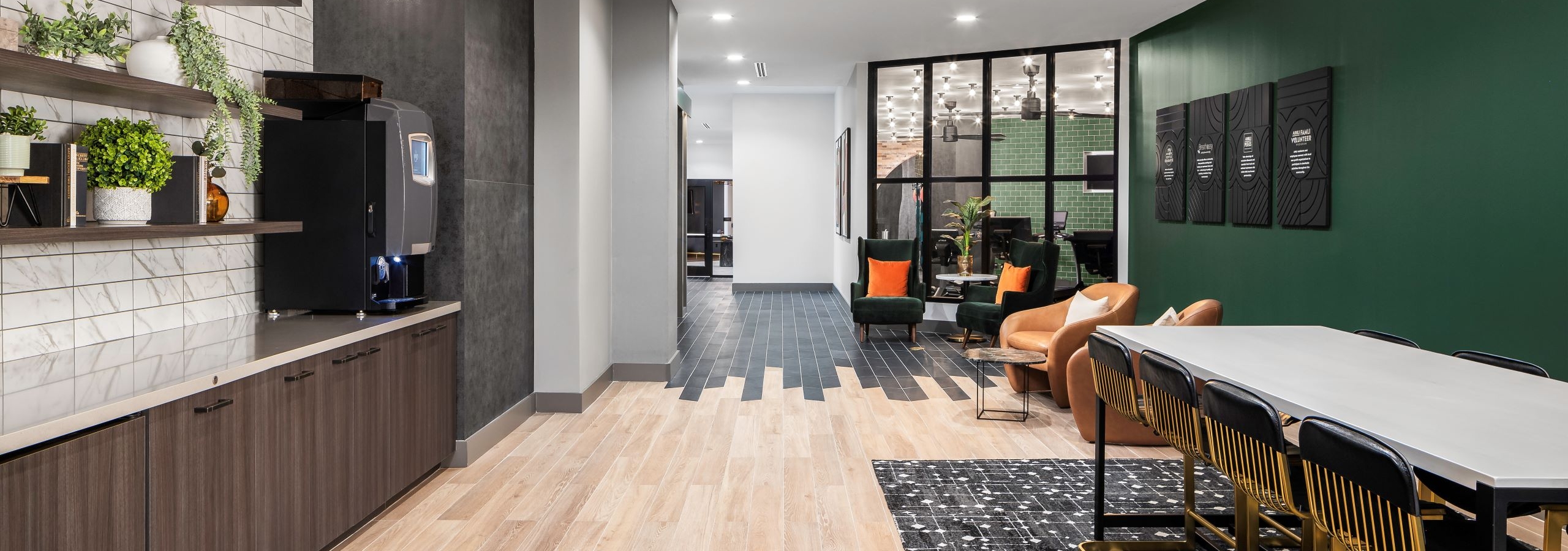 AMLI Flatiron cafe with brown shelves on white and gray tile wall over countertop across from various seating