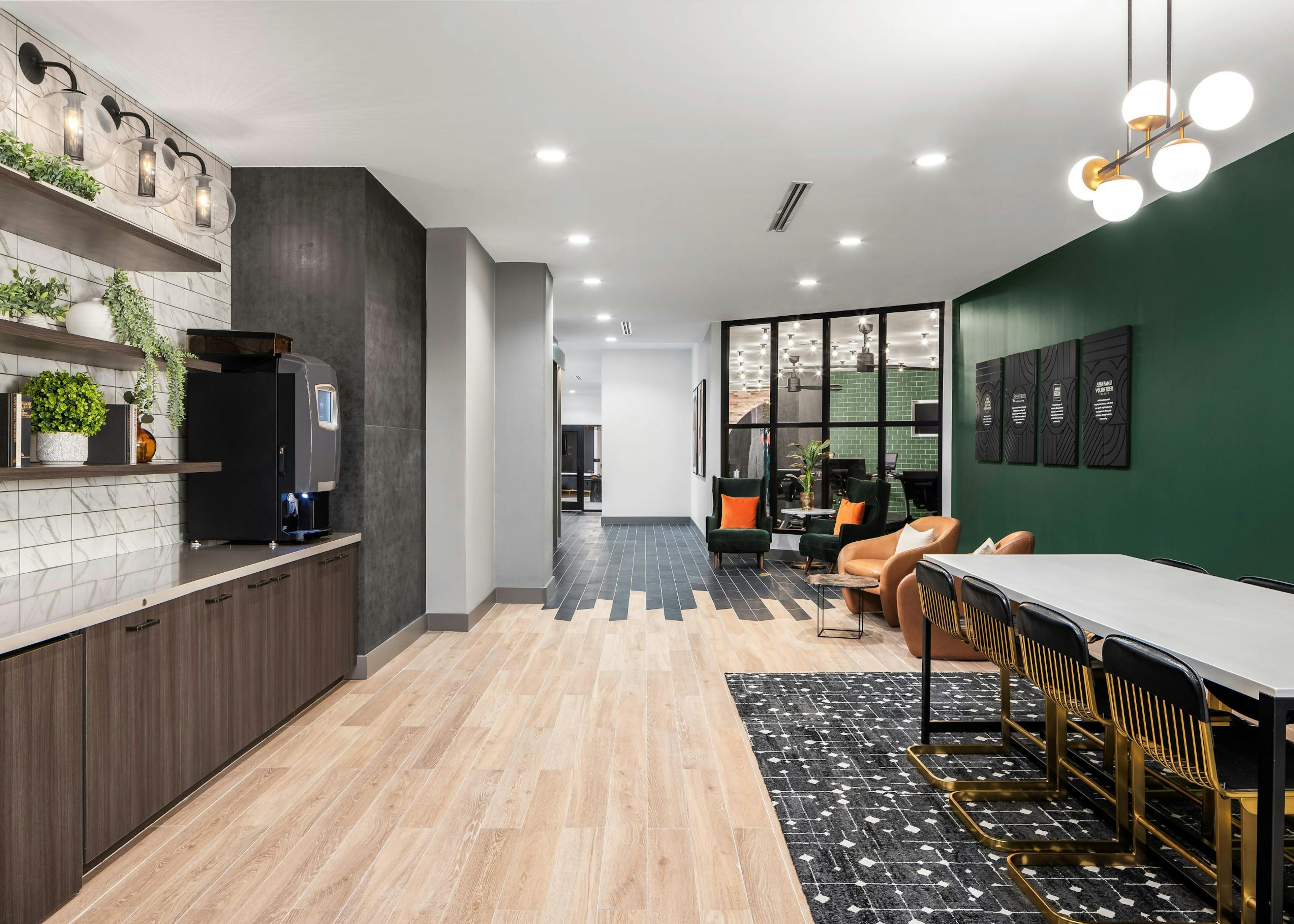 AMLI Flatiron cafe with brown shelves on white and gray tile wall over countertop across from various seating 