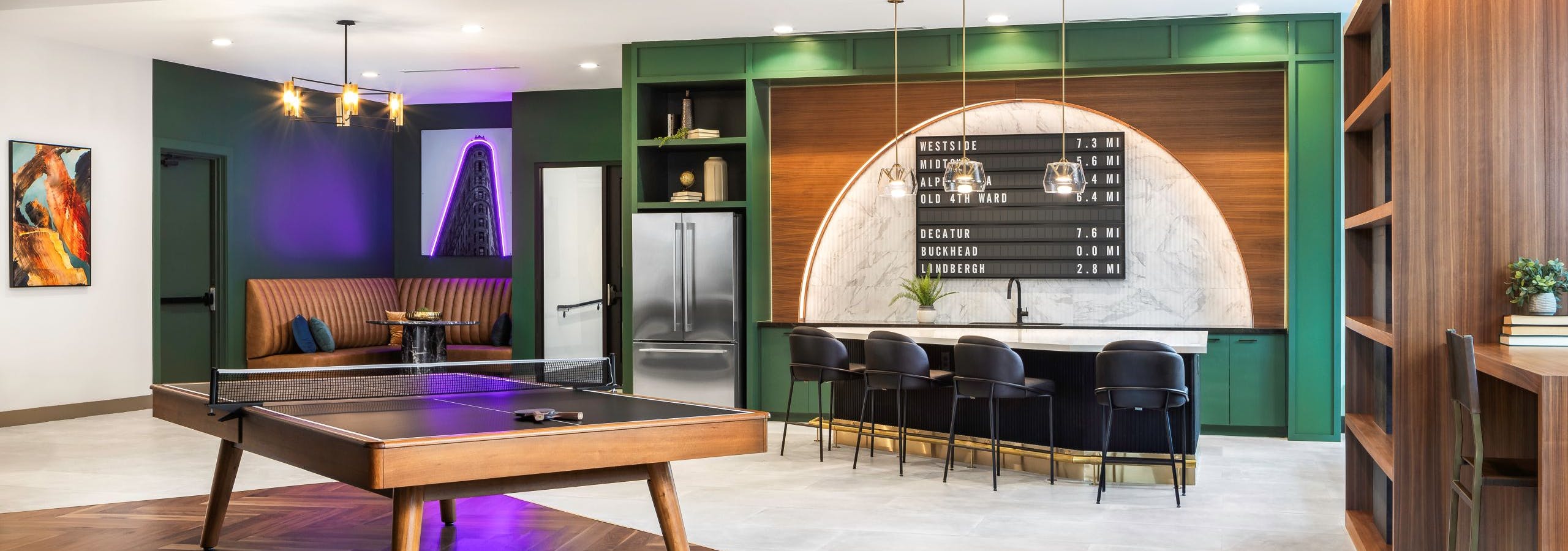 Modern resident lounge at AMLI Flatiron with wood and black ping pong table in front of island with 4 chairs and refrigerator and booth