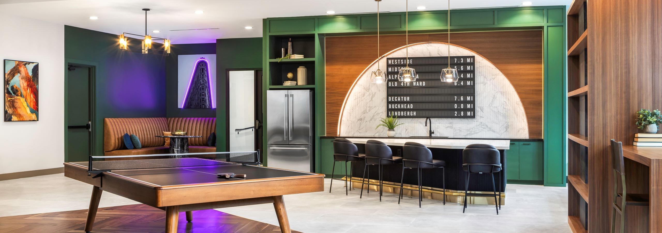 Modern resident lounge at AMLI Flatiron with wood and black ping pong table in front of island with 4 chairs and refrigerator and booth