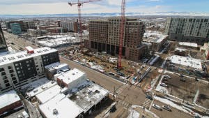 Aerial view of AMLI Golden Triangle construction site with large orange crane erected and buildings all around