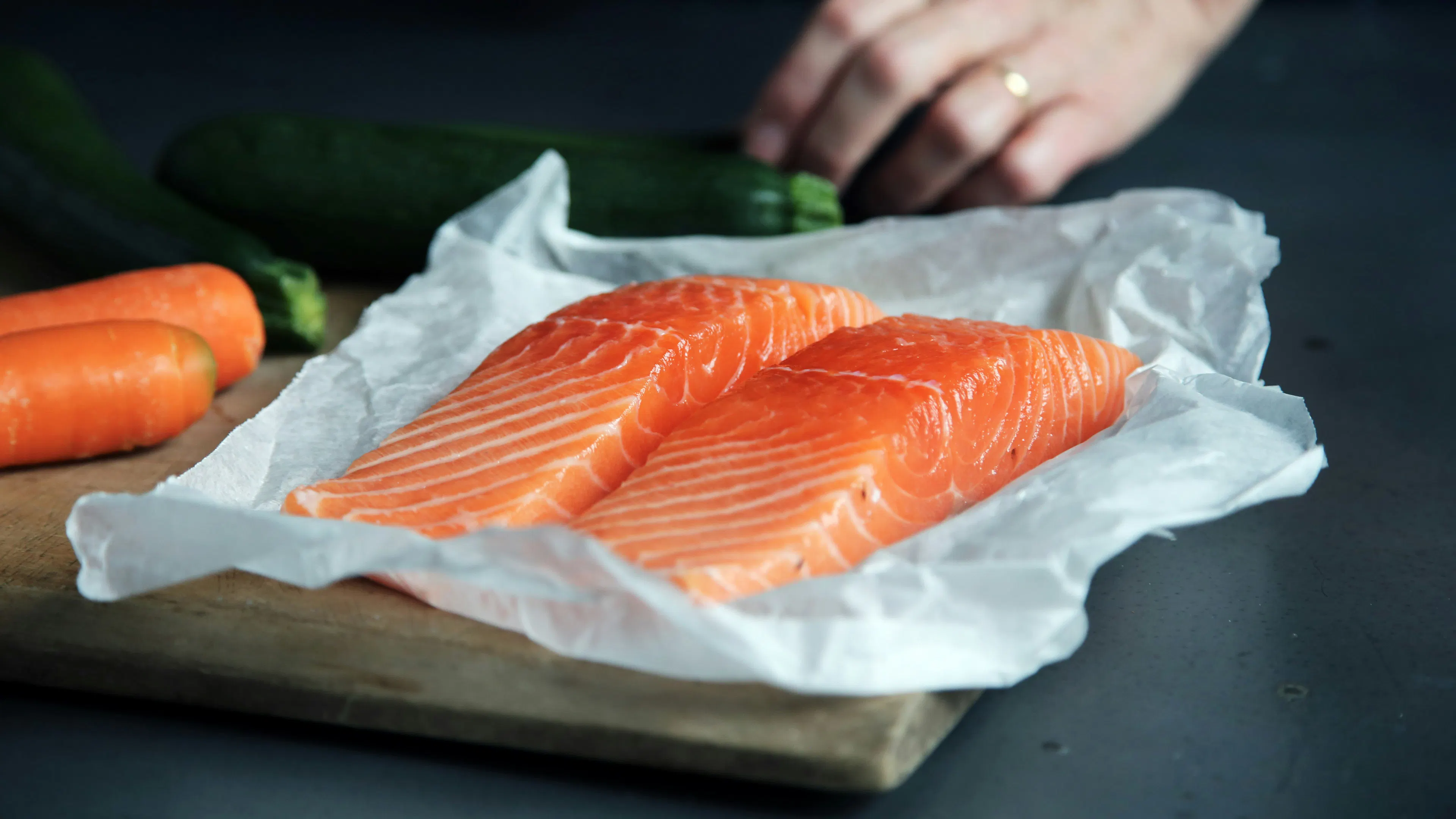 Two raw salmon filets on a tray covered in parchment paper
