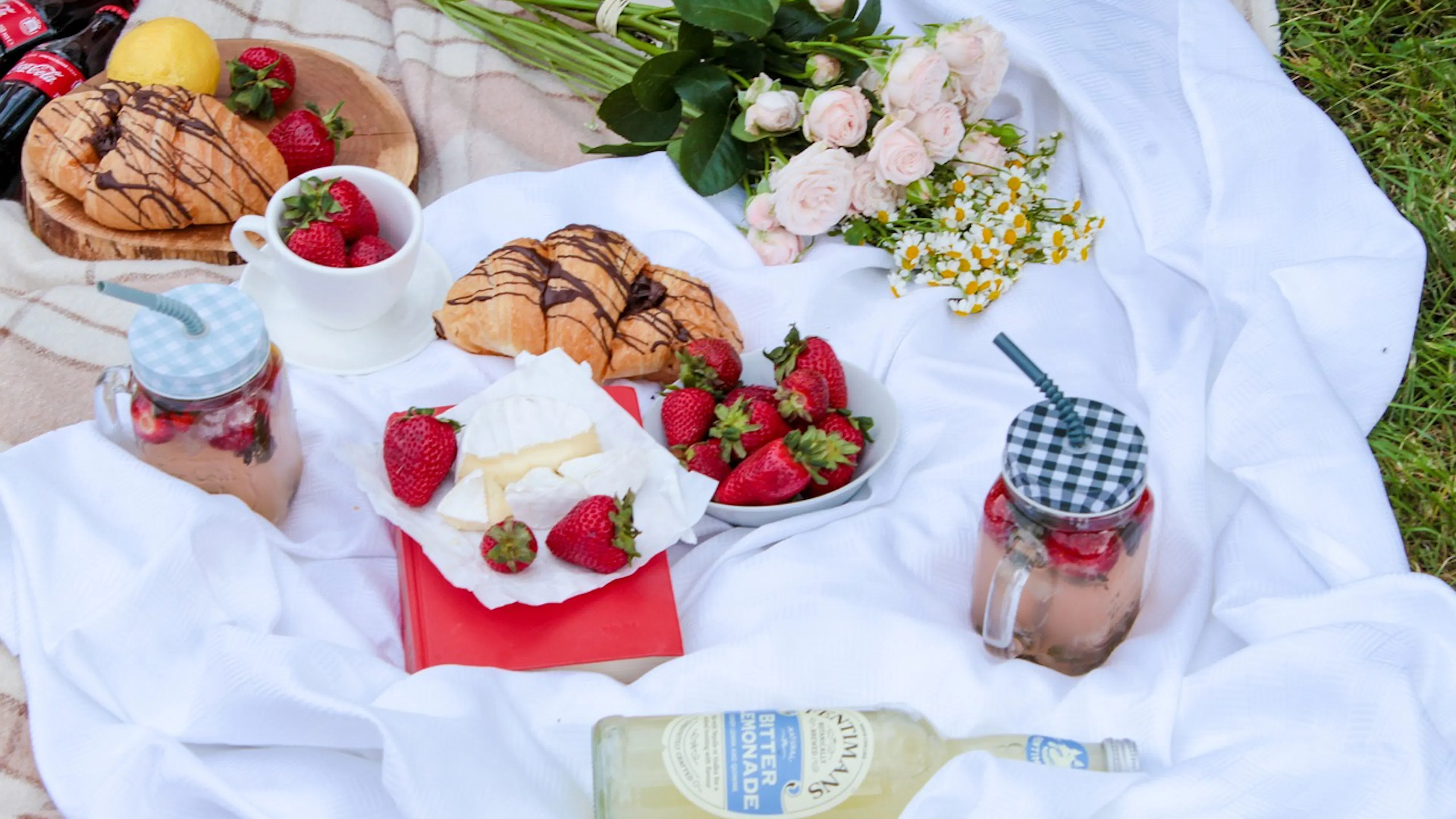 white blanket with strawberries, croissants and wine