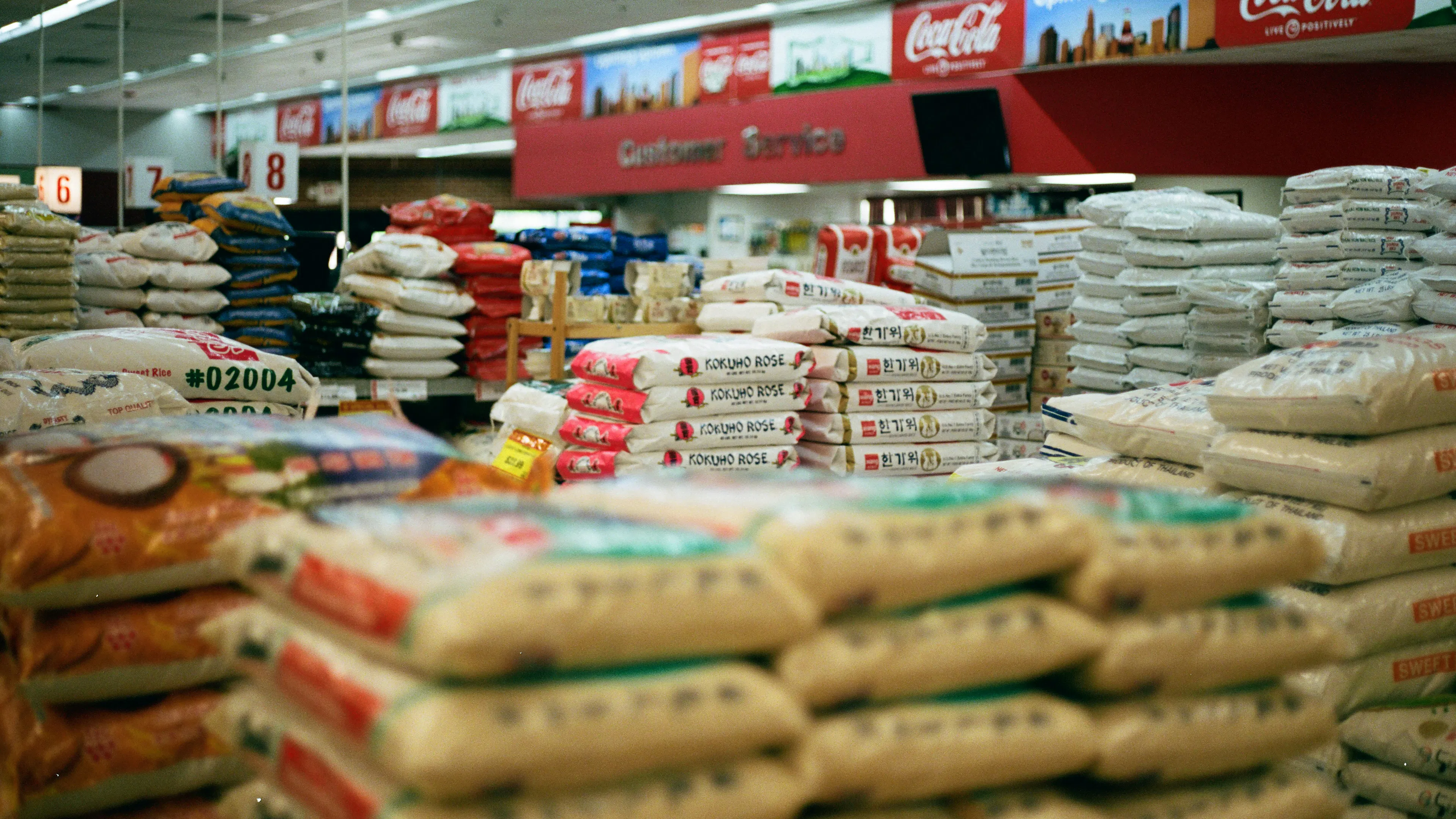 A grocery store full of big bags of rice stacked upon each other