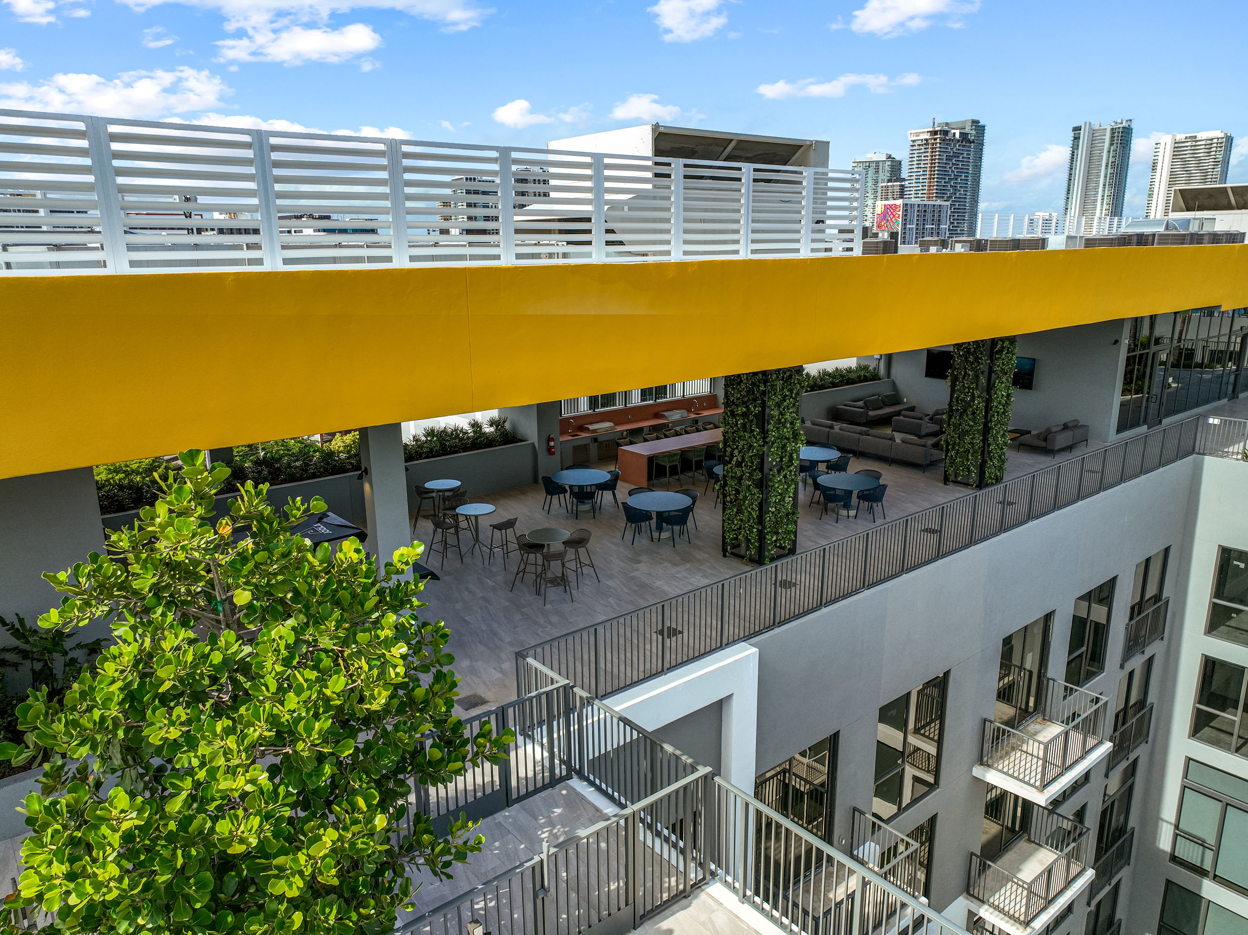 Aerial view of a covered rooftop space at AMLI Wynwood showing a yellow colored ceiling and balconies of apartments