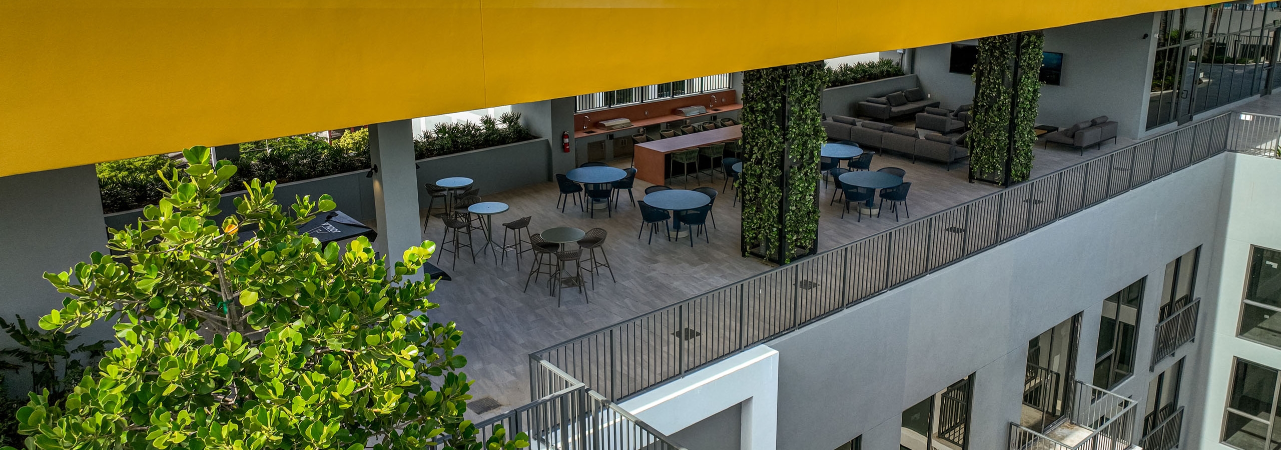 Aerial view of a covered rooftop space at AMLI Wynwood showing a yellow colored ceiling and balconies of apartments