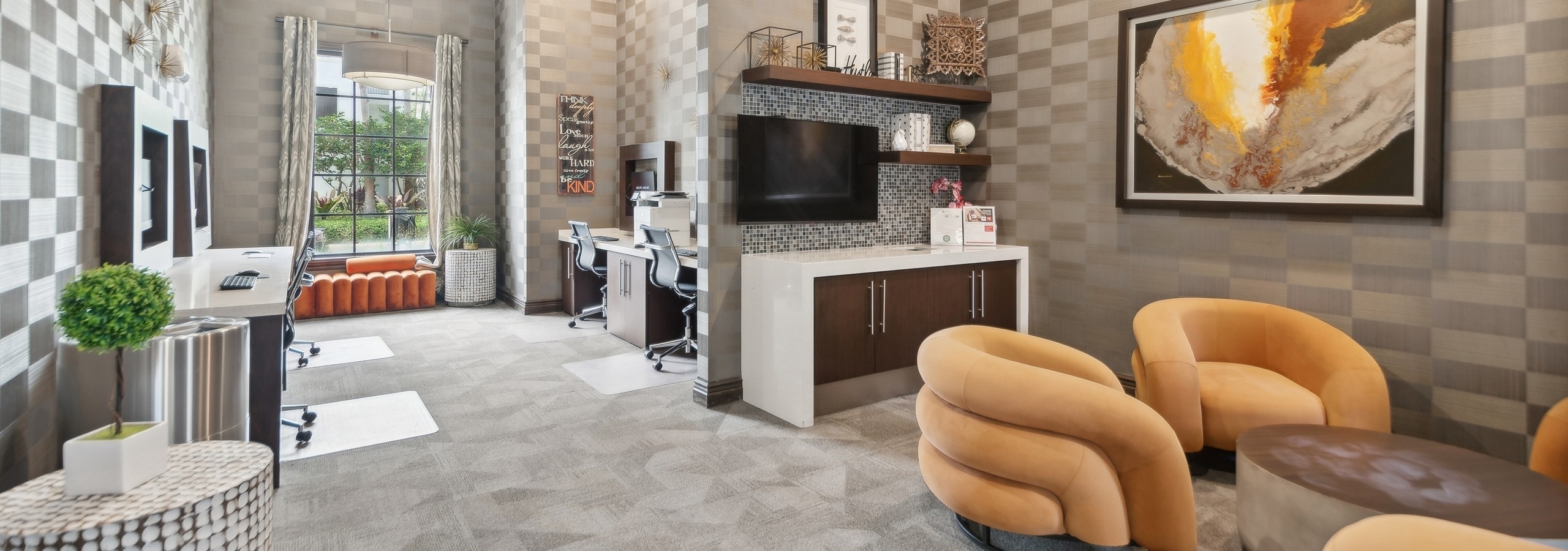 Business center at AMLI Toscana Place apartments with computer stations and printer and seating area with gold comfy chairs