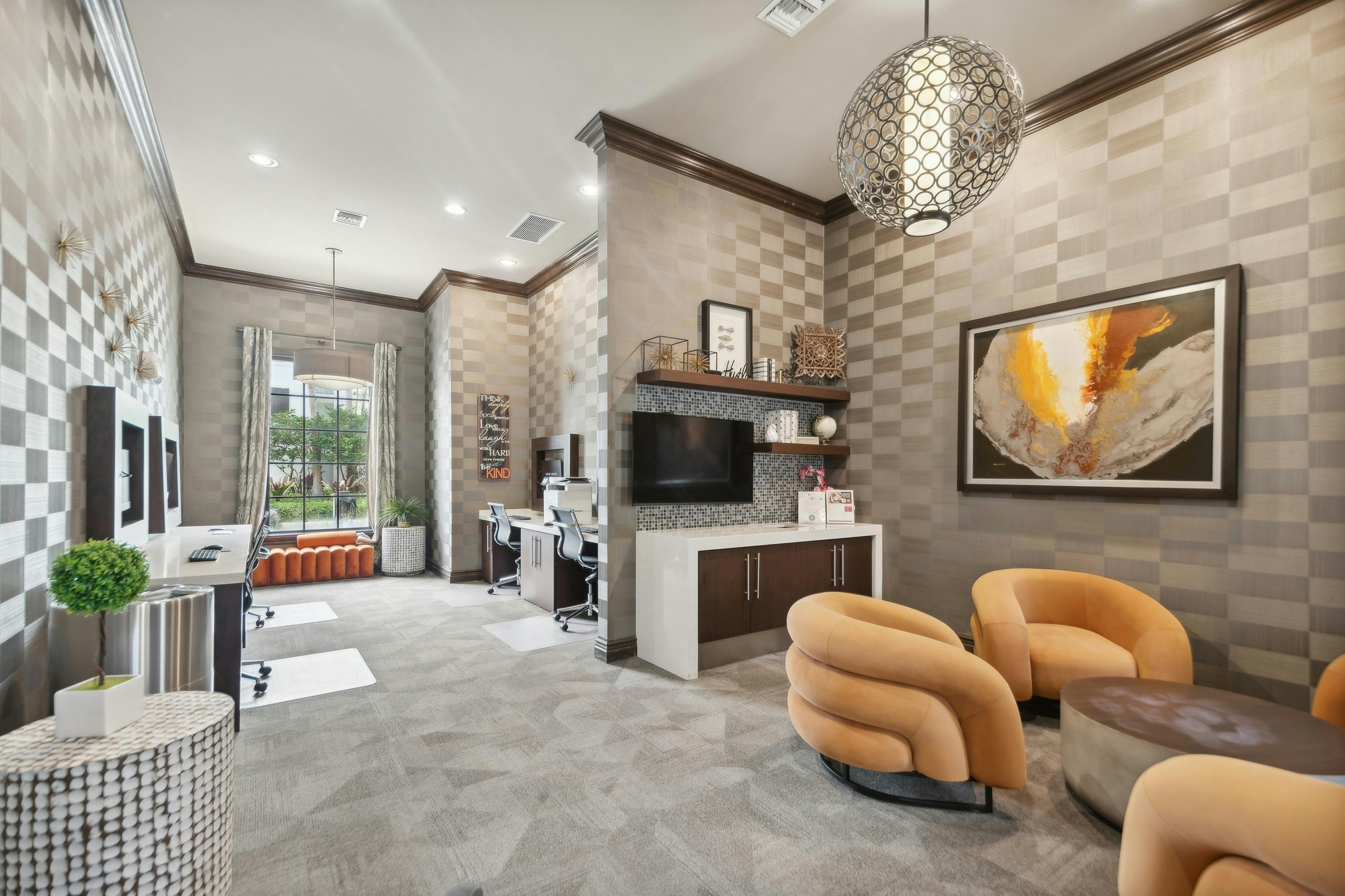 Business center at AMLI Toscana Place apartments with computer stations and printer and seating area with gold comfy chairs