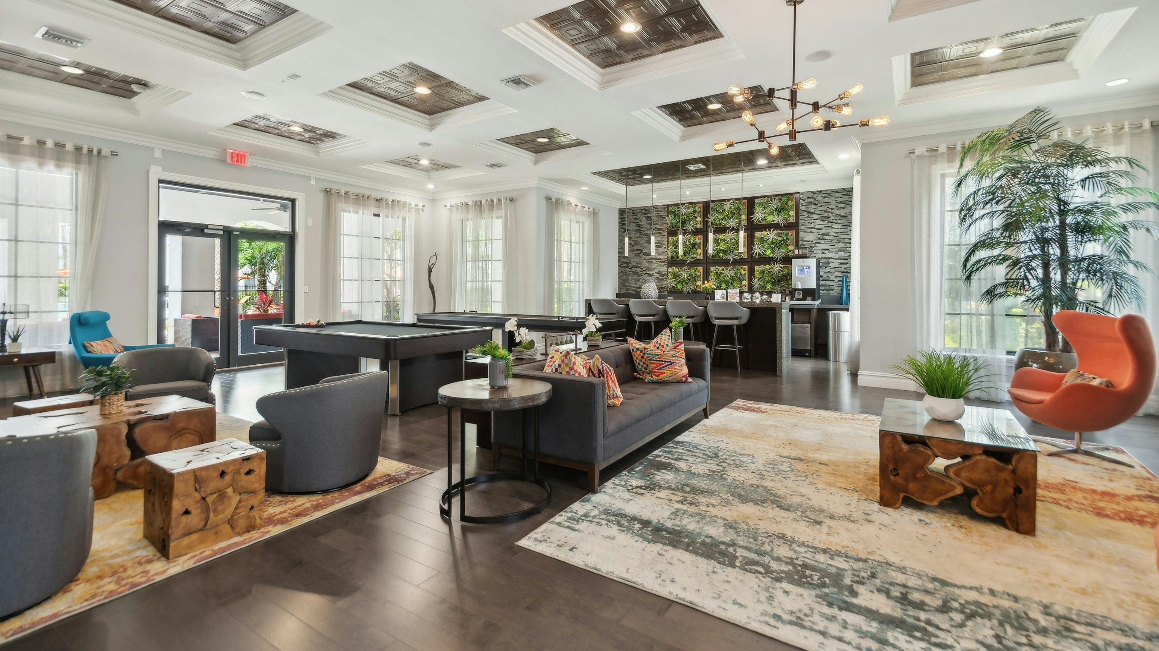 Resident lounge at AMLI Toscana Place apartments showing a coffered ceiling over designer furniture and a coffee bar andbilliards table

Â 
