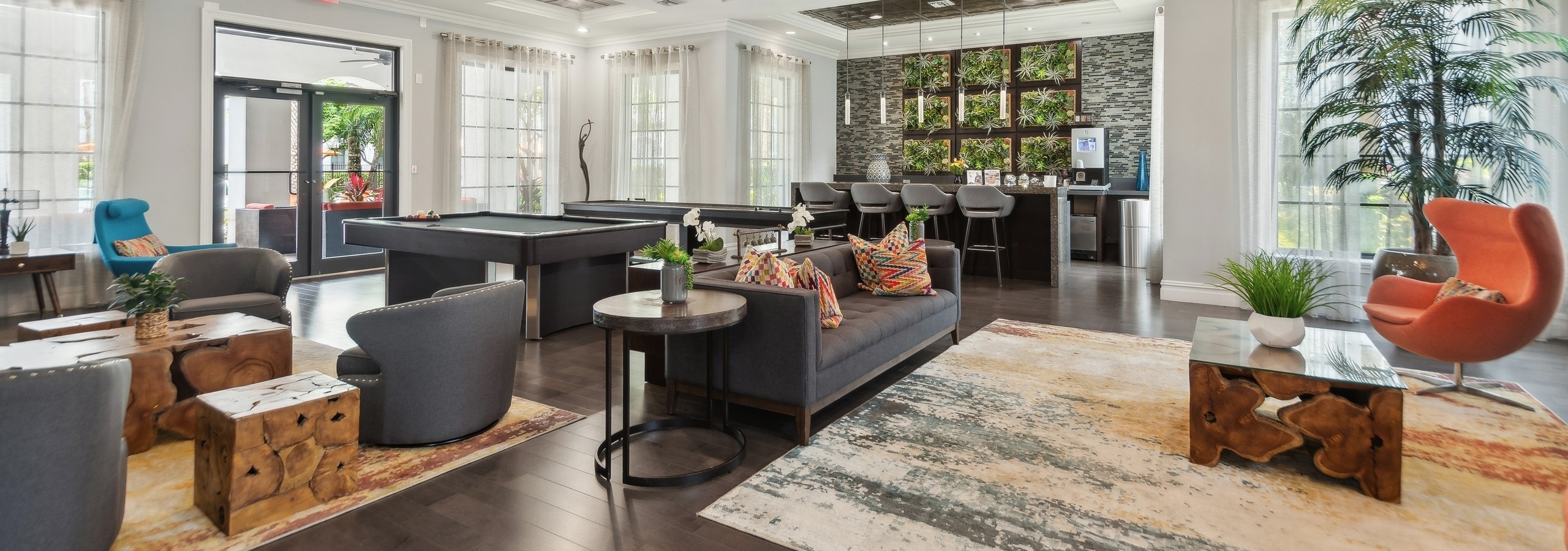 Resident lounge at AMLI Toscana Place apartments showing a coffered ceiling over designer furniture and a coffee bar and billiards table