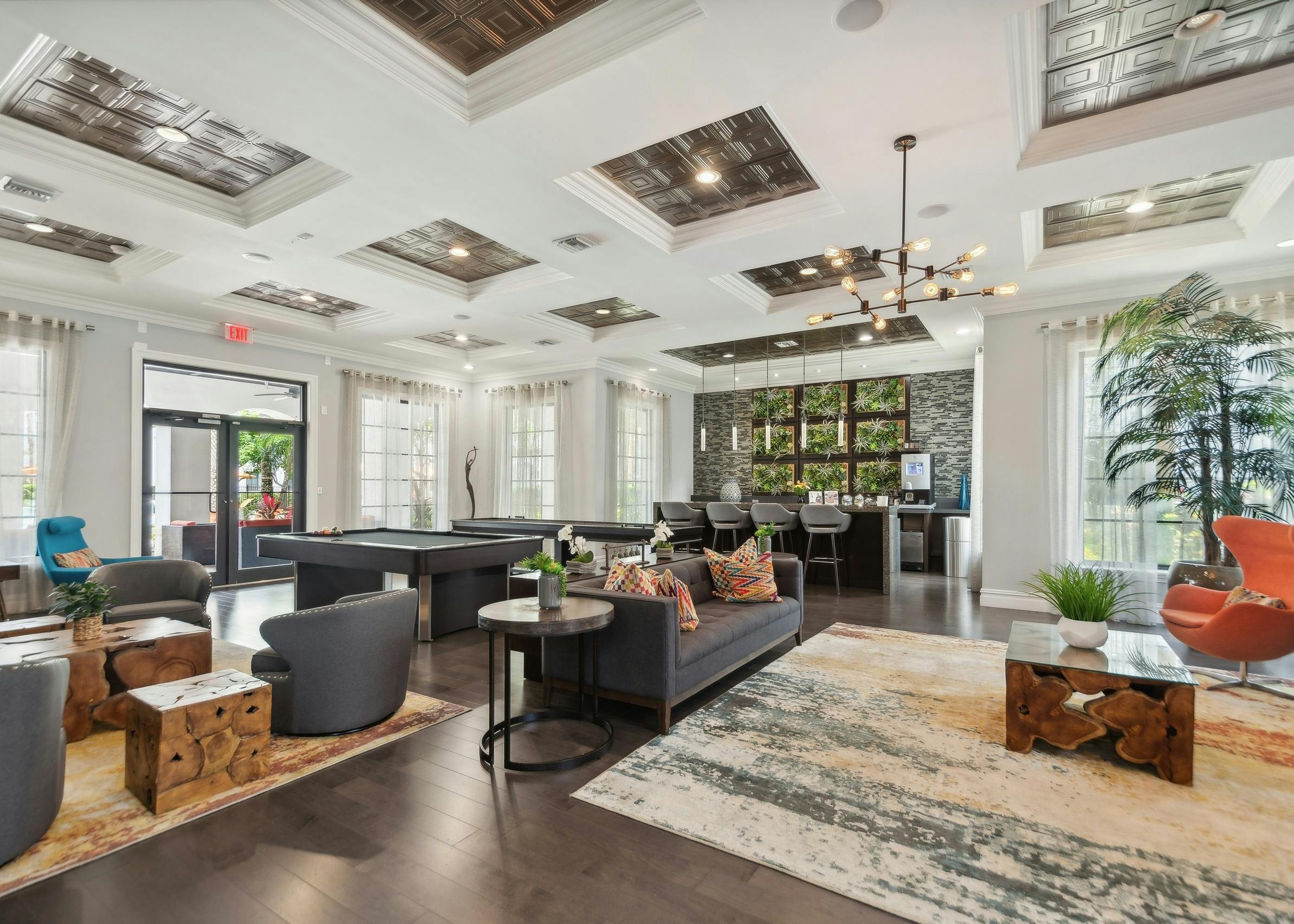 Resident lounge at AMLI Toscana Place apartments showing a coffered ceiling over designer furniture and a coffee bar andbilliards table