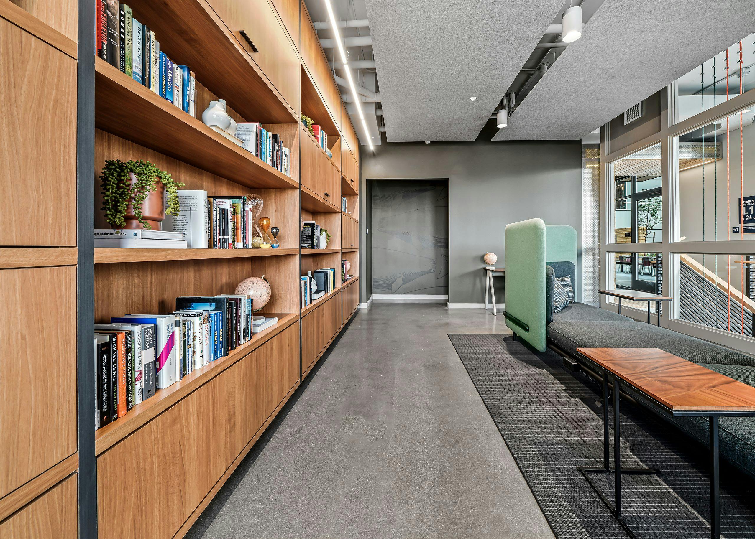 AMLI Spring District library with high ceilings and comfy booth and wood wall of shelves filled with books