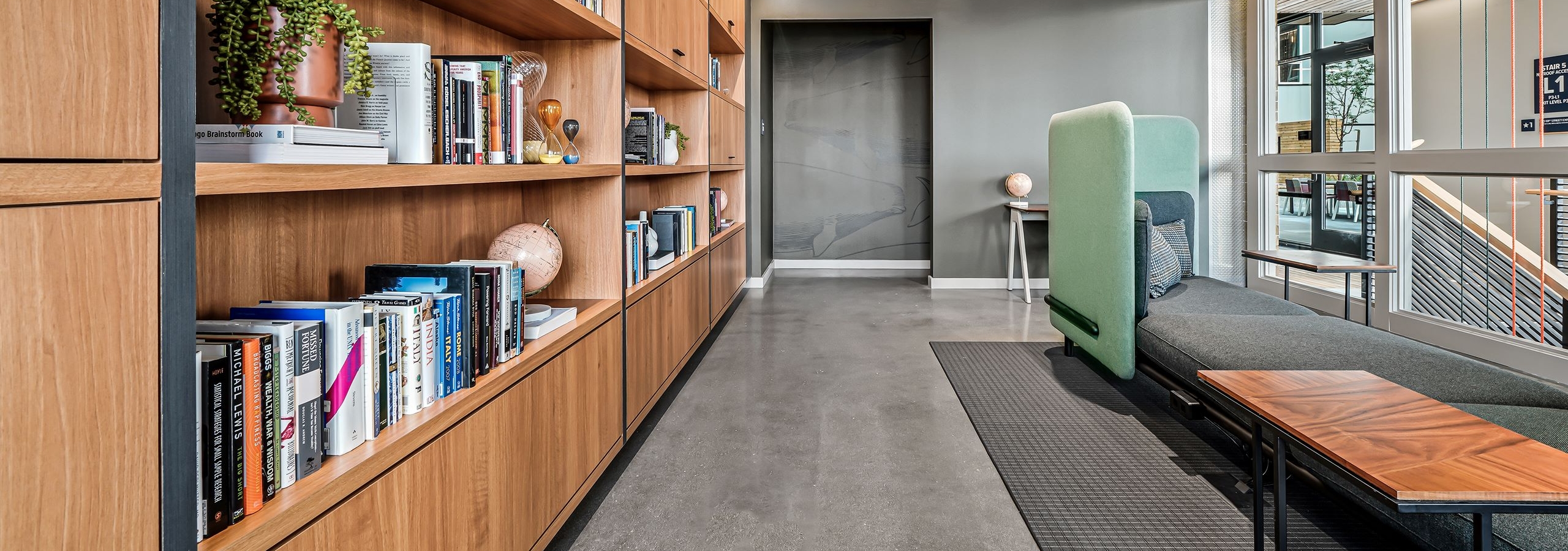 AMLI Spring District library with high ceilings and comfy booth and wood wall of shelves filled with books