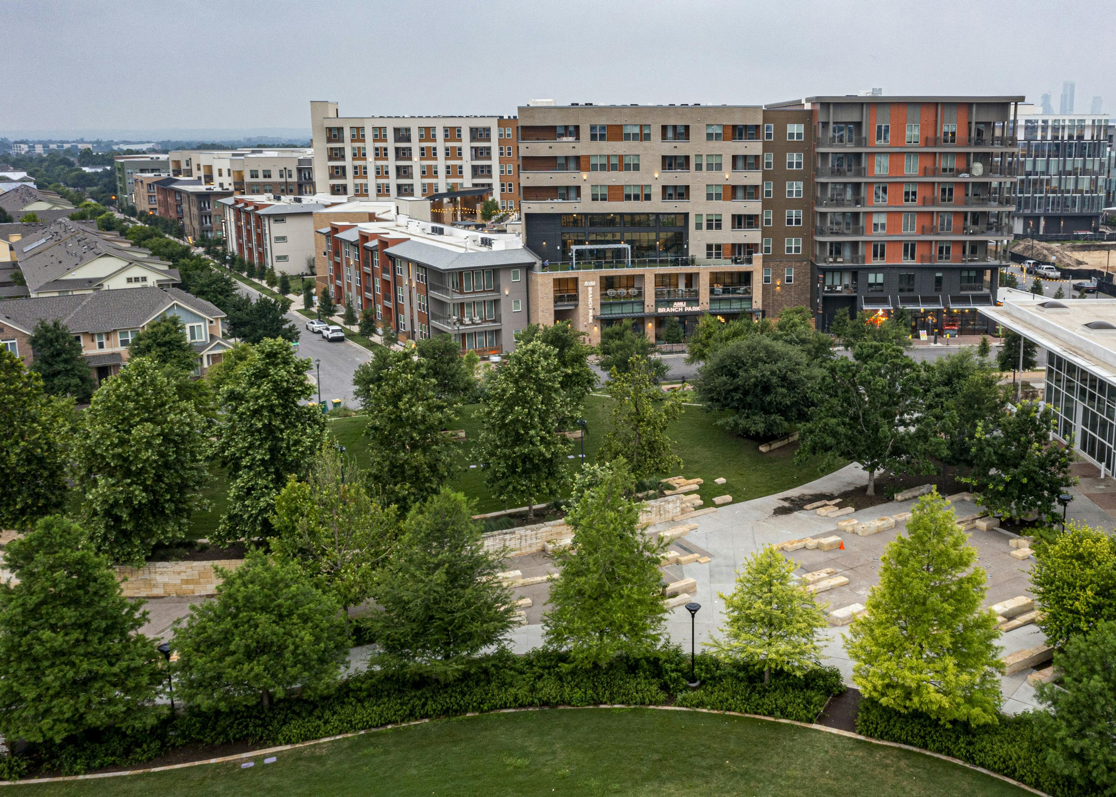 Aerial view of AMLI Branch Park featuring modern buildings of varying heights and designs overseeing a park with lush green trees