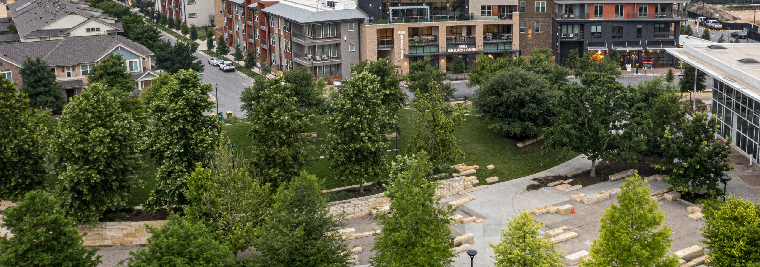 Aerial view of AMLI Branch Park featuring modern buildings of varying heights and designs overseeing a park with lush green trees