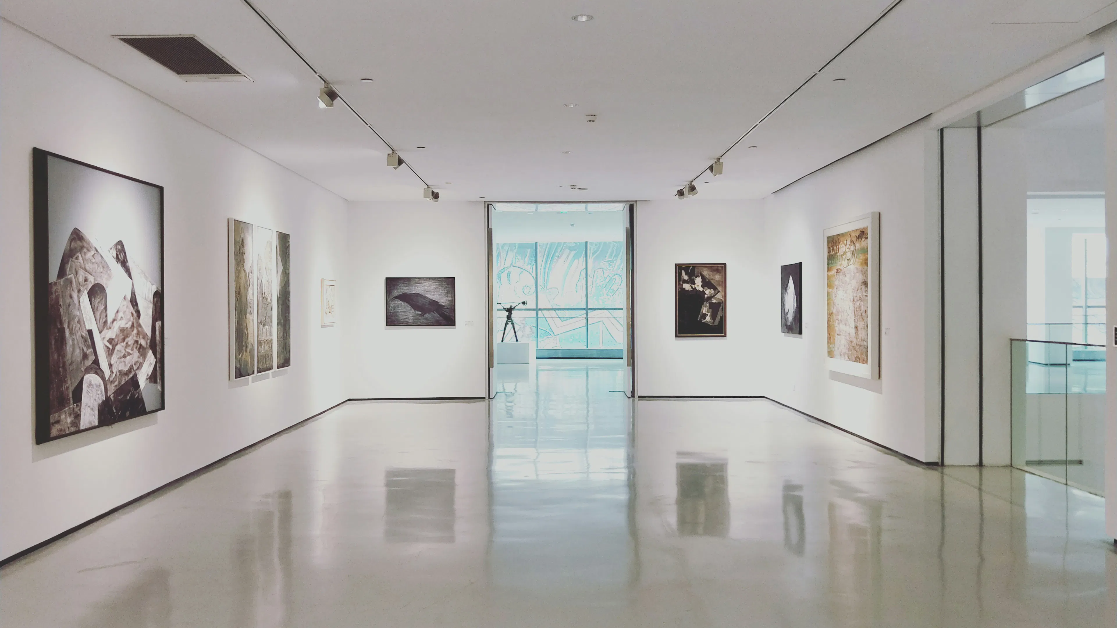 The inside of a modern art museum with white walls and large pieces of art