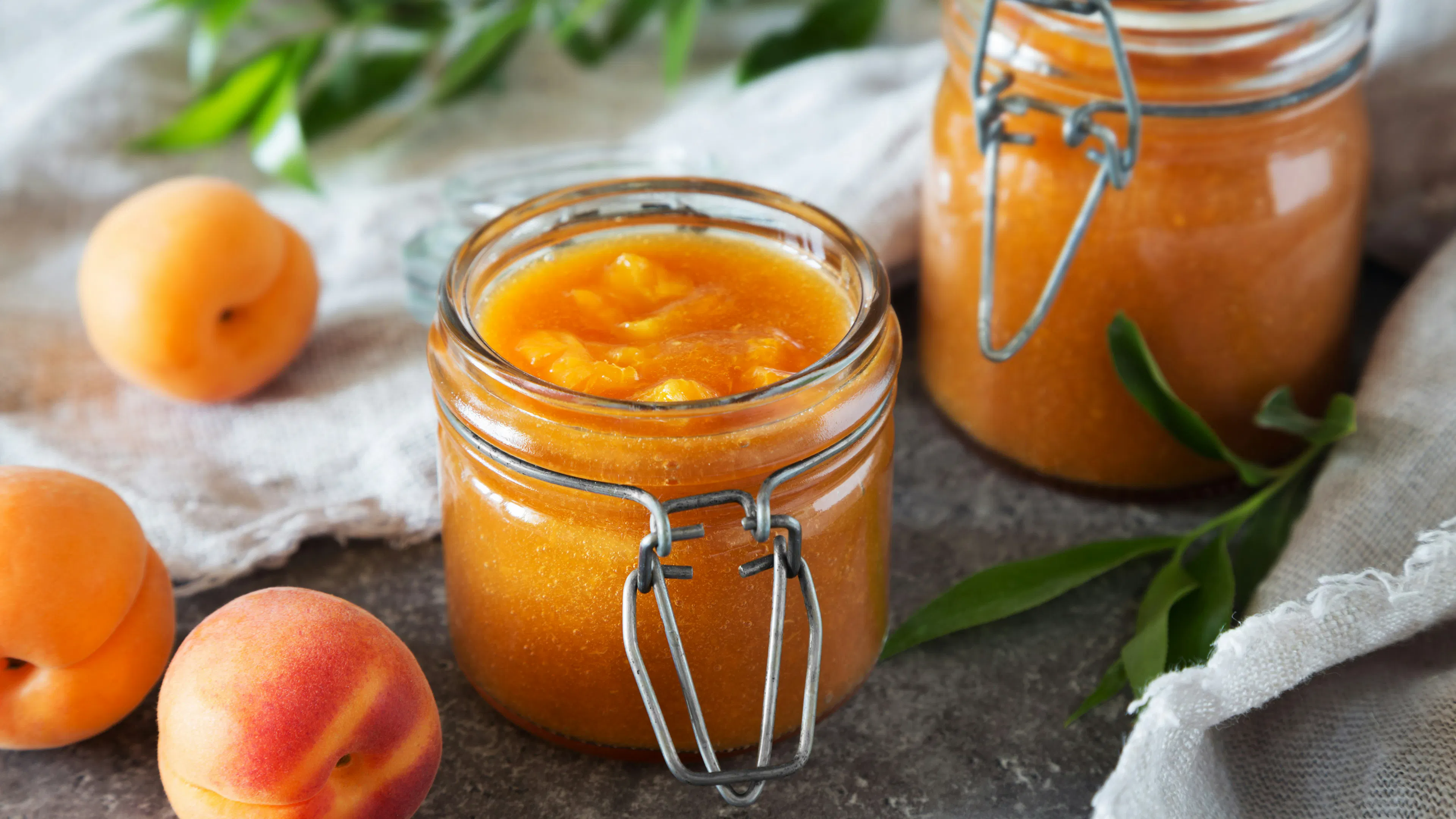 A small glass jar filled with homemade peach jam