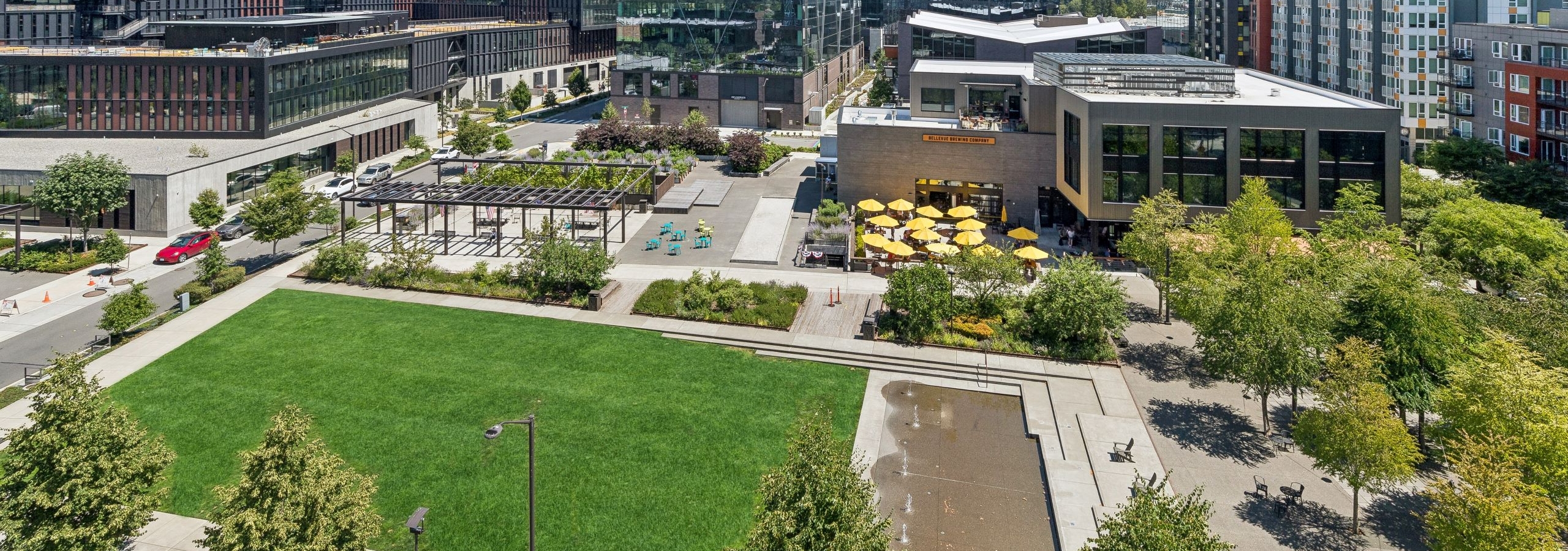 View of park from AMLI Spring District apartment building showing grassy area and fountain and other buildings