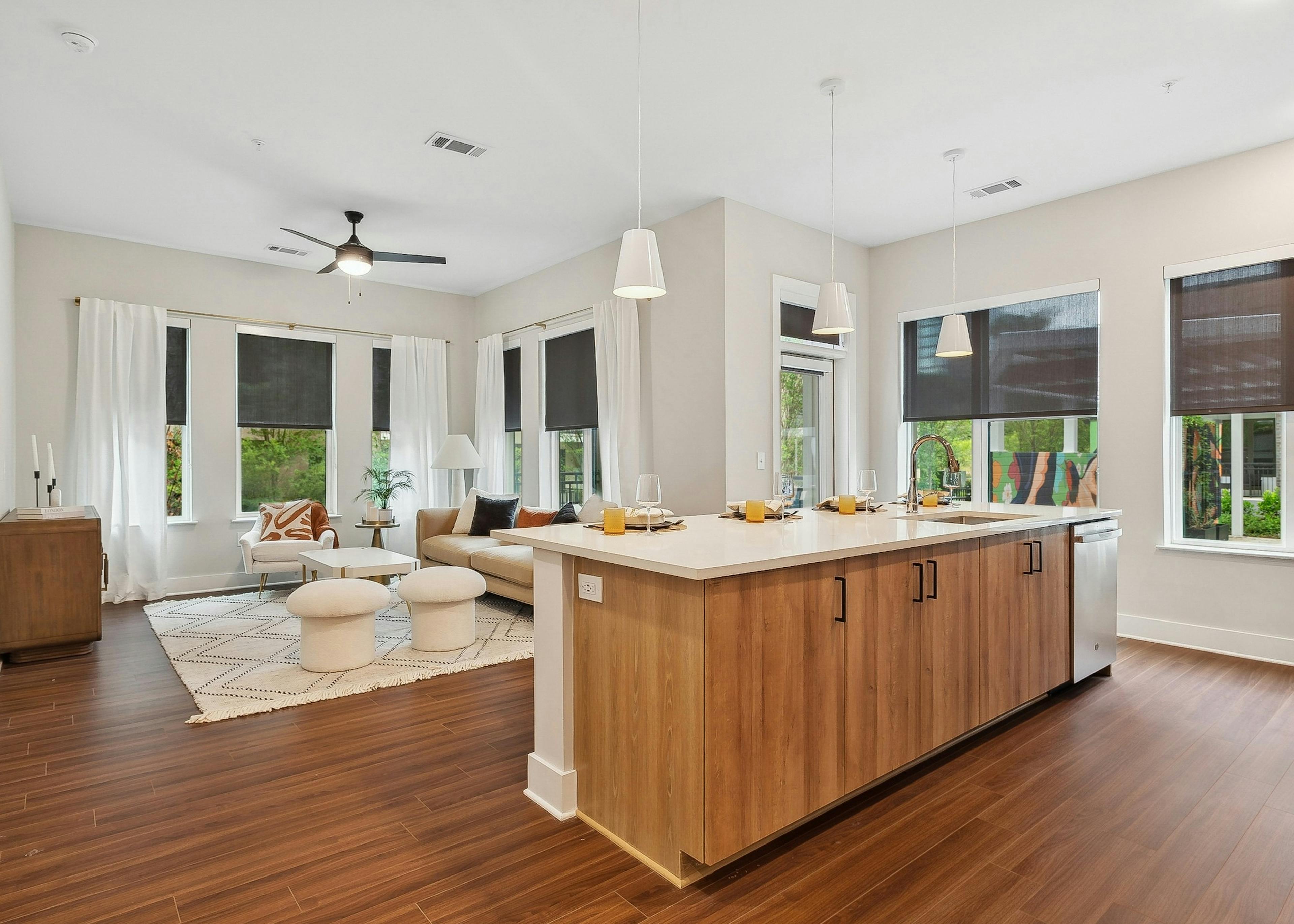 A kitchen island overlooking an open concept living room with wood floors at AMLI Flatiron with a with a sectional sofa and coffee table