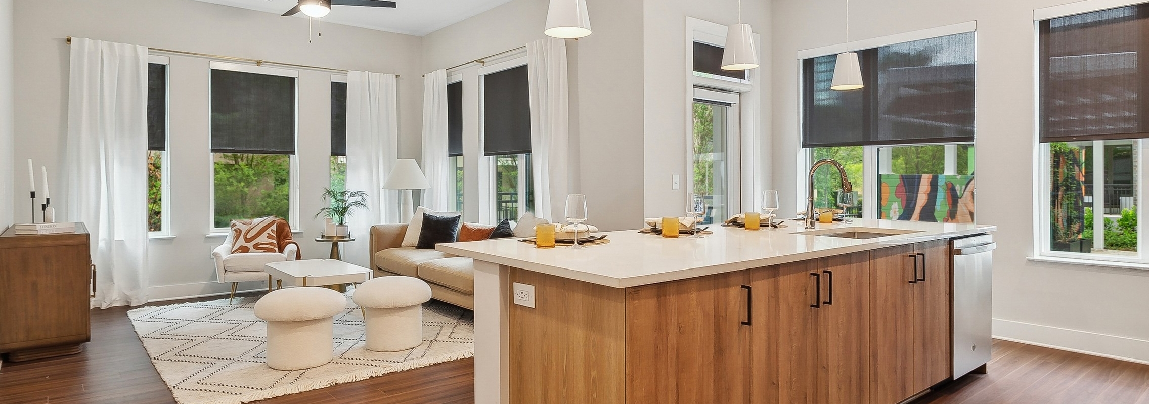 A kitchen island overlooking an open concept living room with wood floors at AMLI Flatiron with a with a sectional sofa and coffee table
