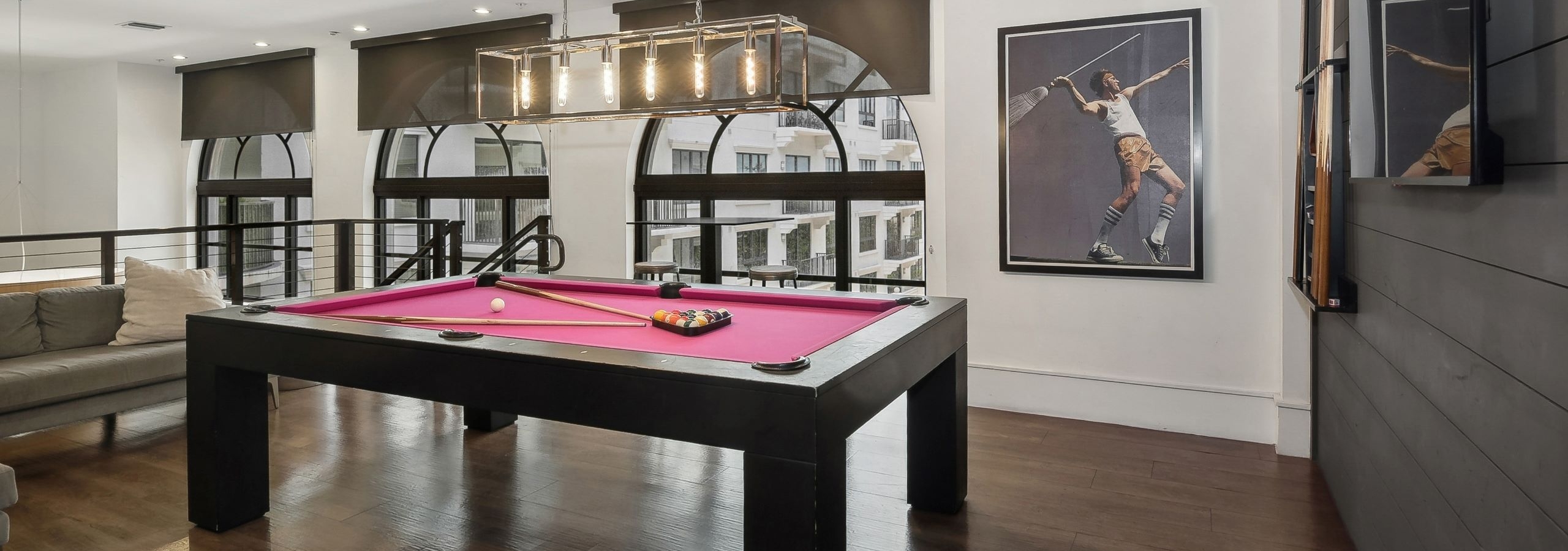 Second floor interior view of the AMLI Joya two story game room with red felt  billiards table and artwork of tennis player
