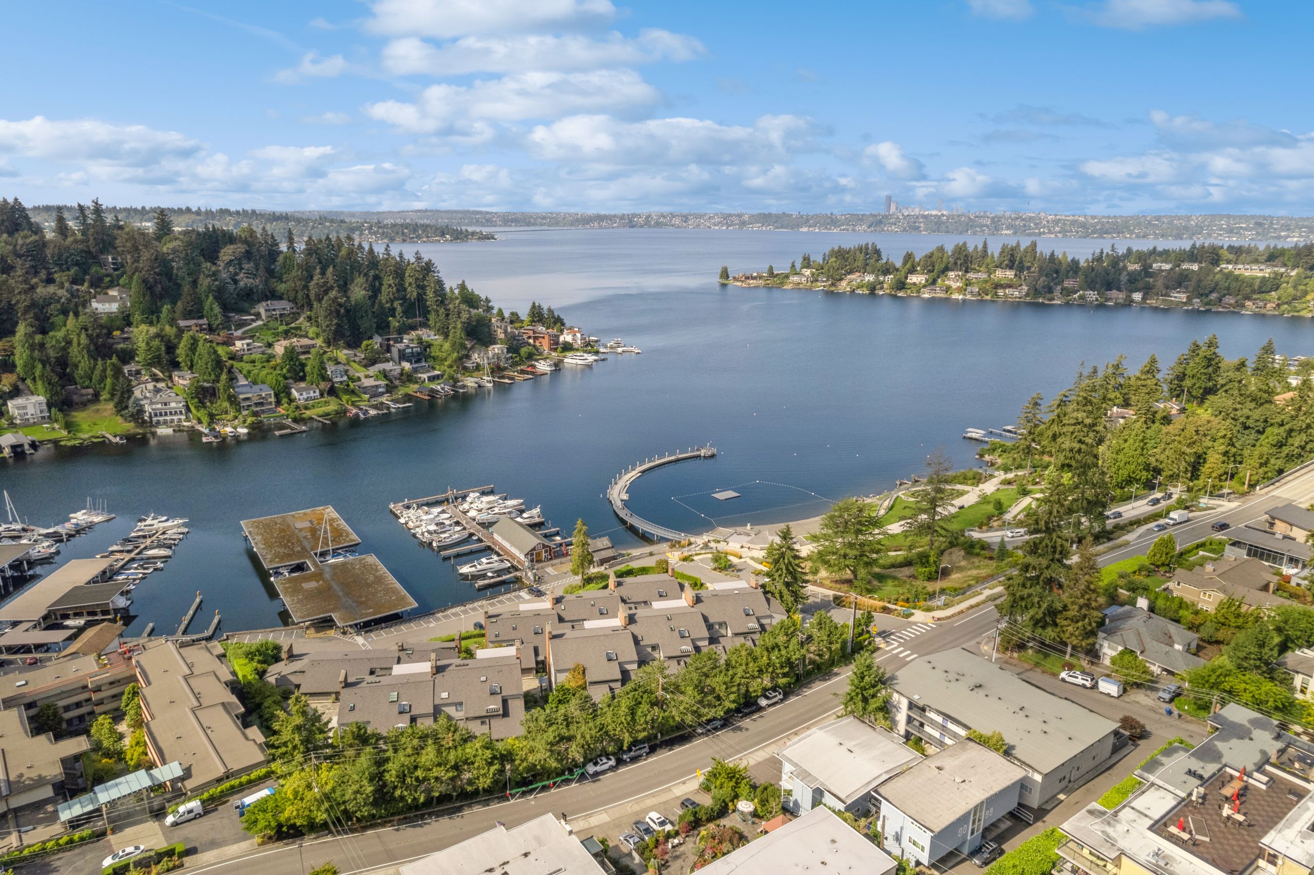 Aerial view of Lake Washington and neighborhood surrounding AMLI Bellevue Park apartments under a bright blue sky with a few clouds
