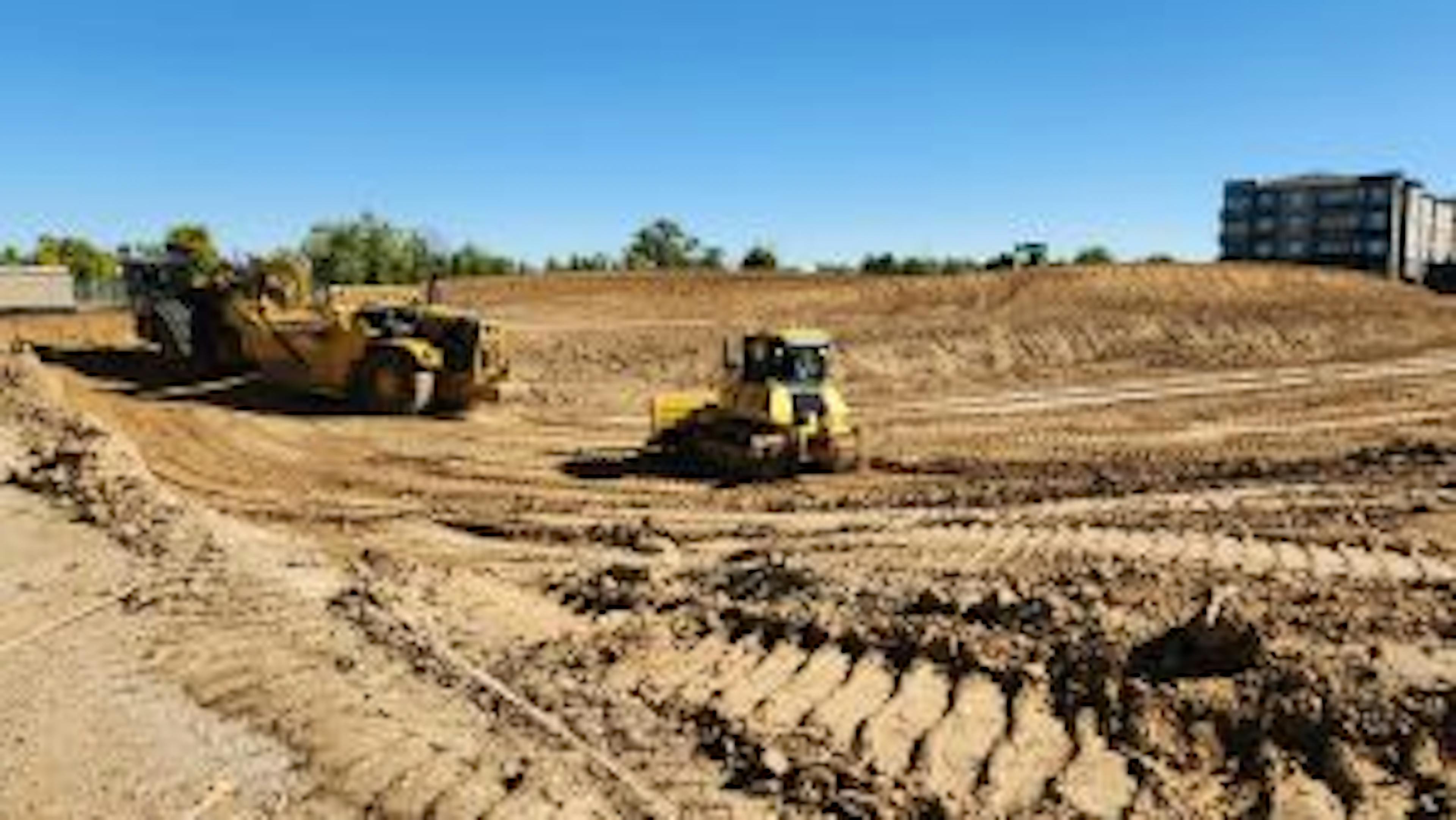 Construction equipment in middle of dirt doing site grading work at AMLI Village Park apartments