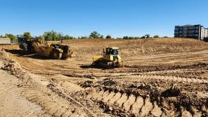 Construction equipment in middle of dirt doing site grading work at AMLI Village Park apartments