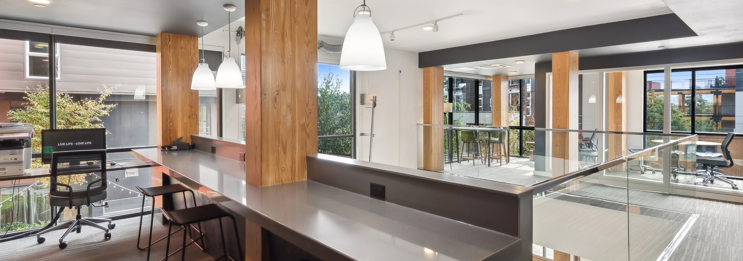 Business center at AMLI Wallingford apartments featuring a print station and small offices for working from home and many windows.