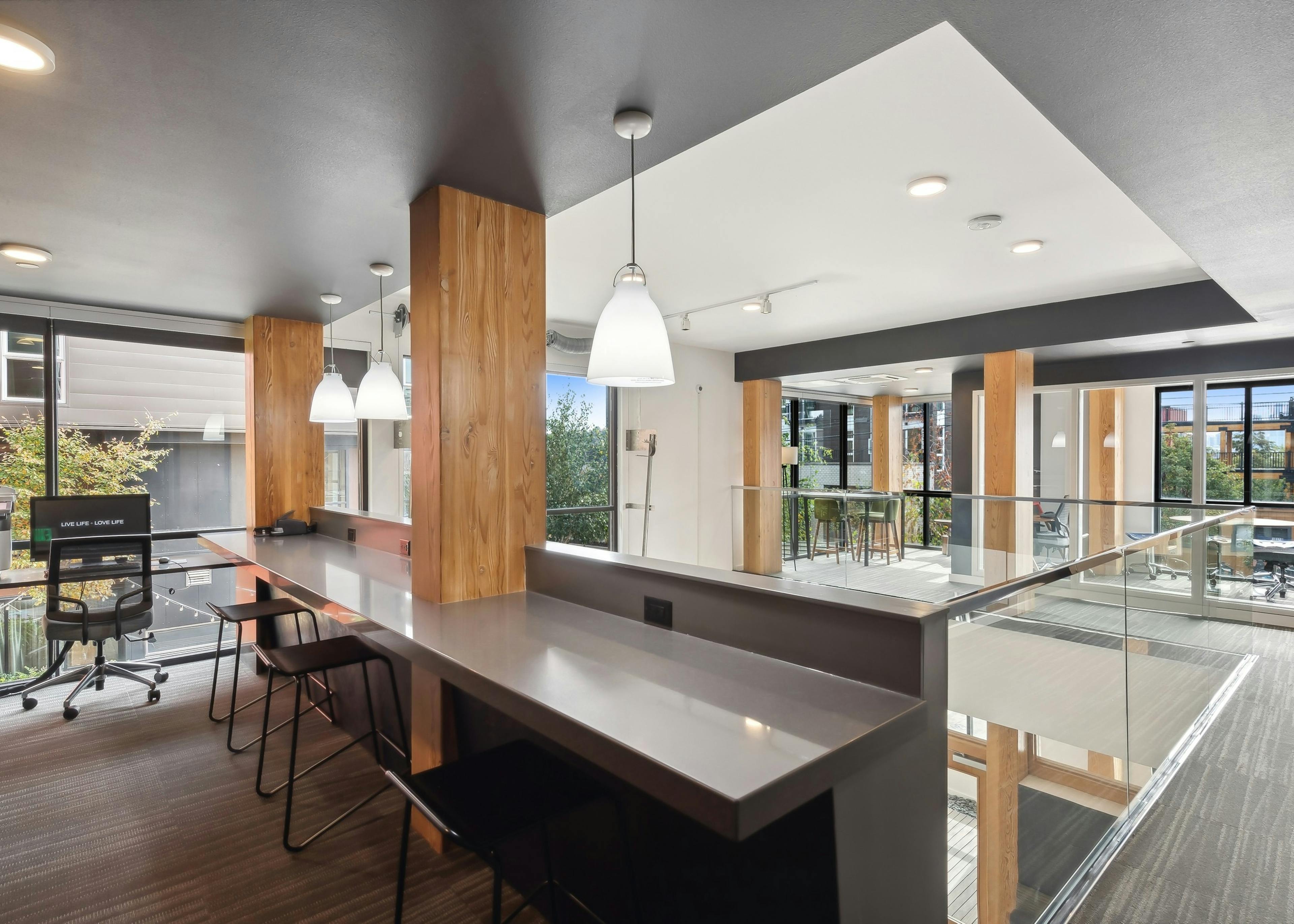 Business center at AMLI Wallingford apartments featuring a print station and small offices for working from home and many windows.