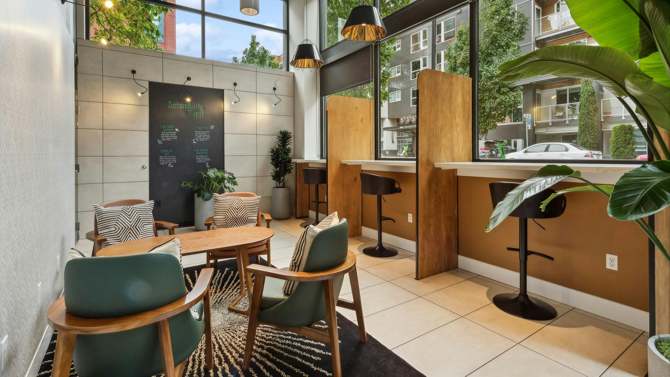 Coworking space at AMLI South Lake Union apartments featuring booths, other seating and windows that face the street.