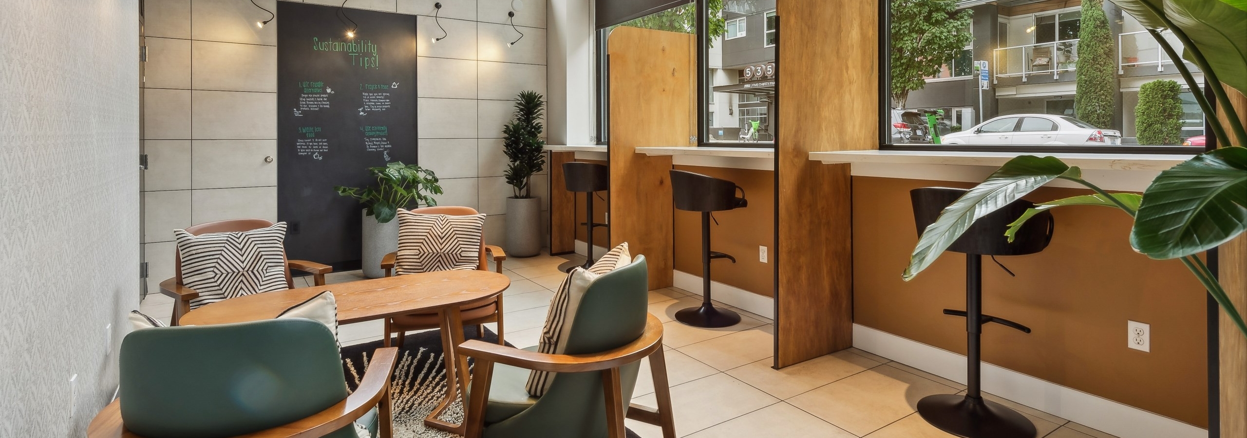 Coworking space at AMLI South Lake Union apartments featuring booths, other seating and windows that face the street.