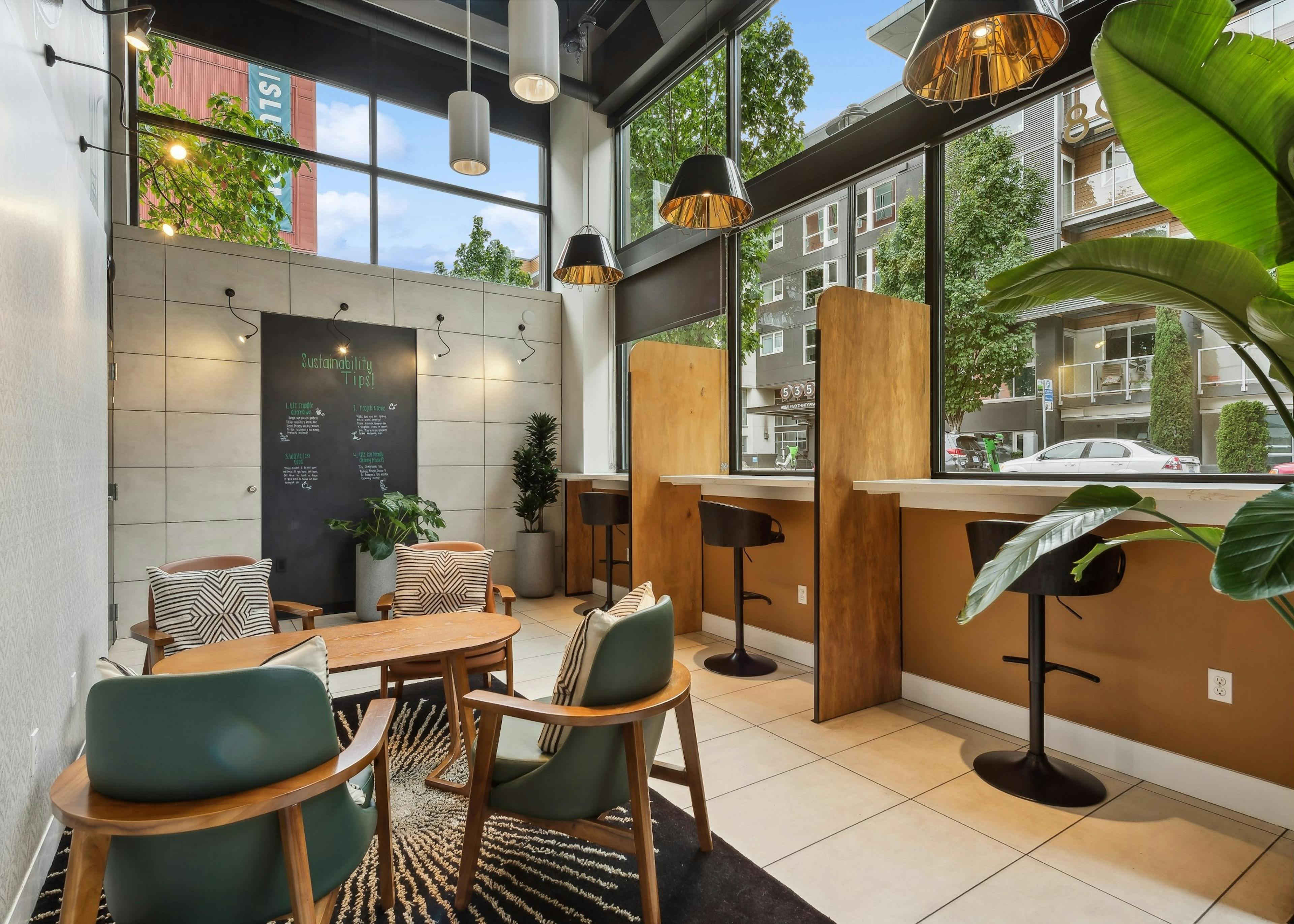 Coworking space at AMLI South Lake Union apartments featuring booths, other seating and windows that face the street.