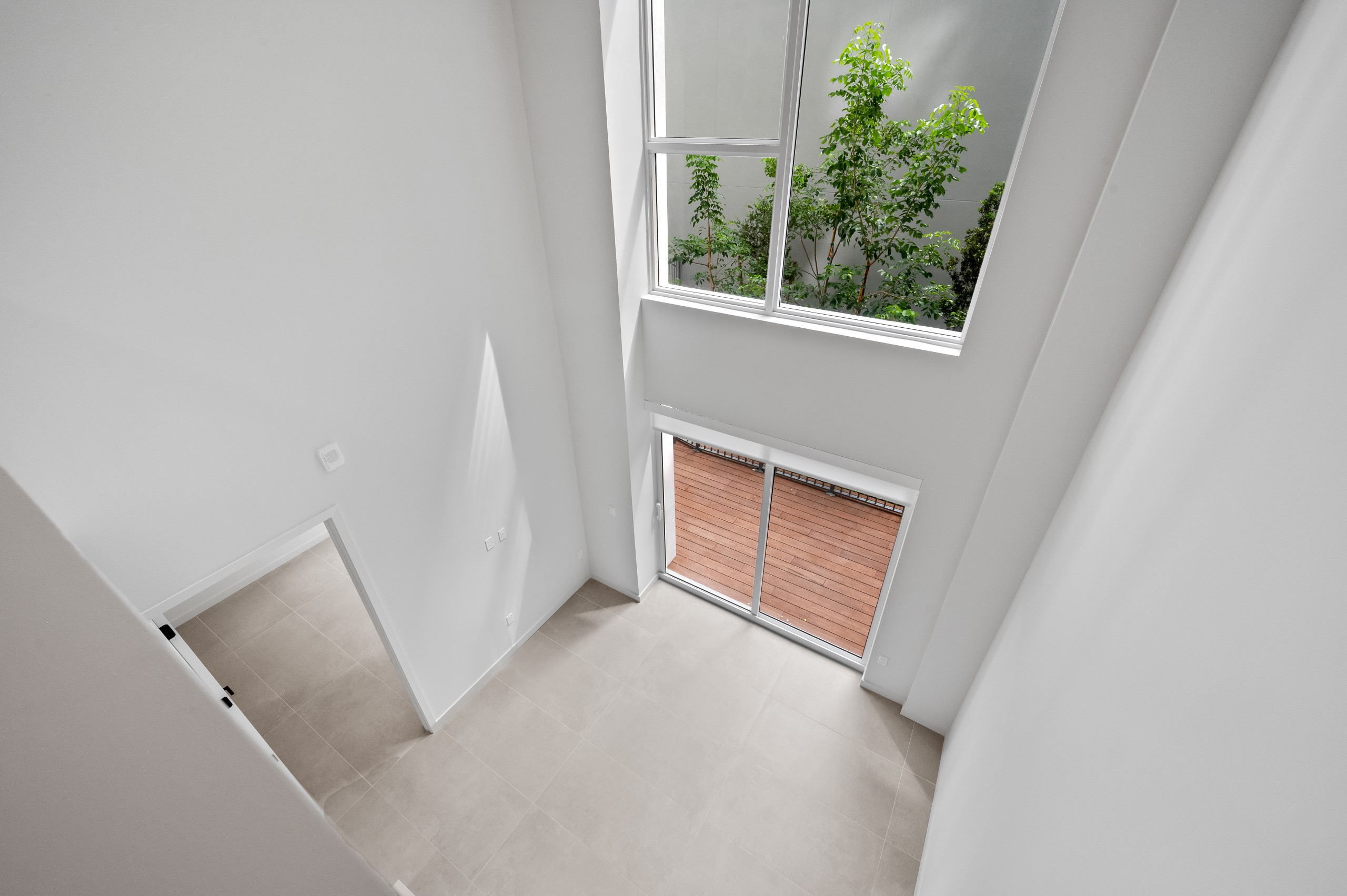 Overhead view of two story loft living area with large windows above sliding doors leading to private patio at AMLI Wynwood apartments.