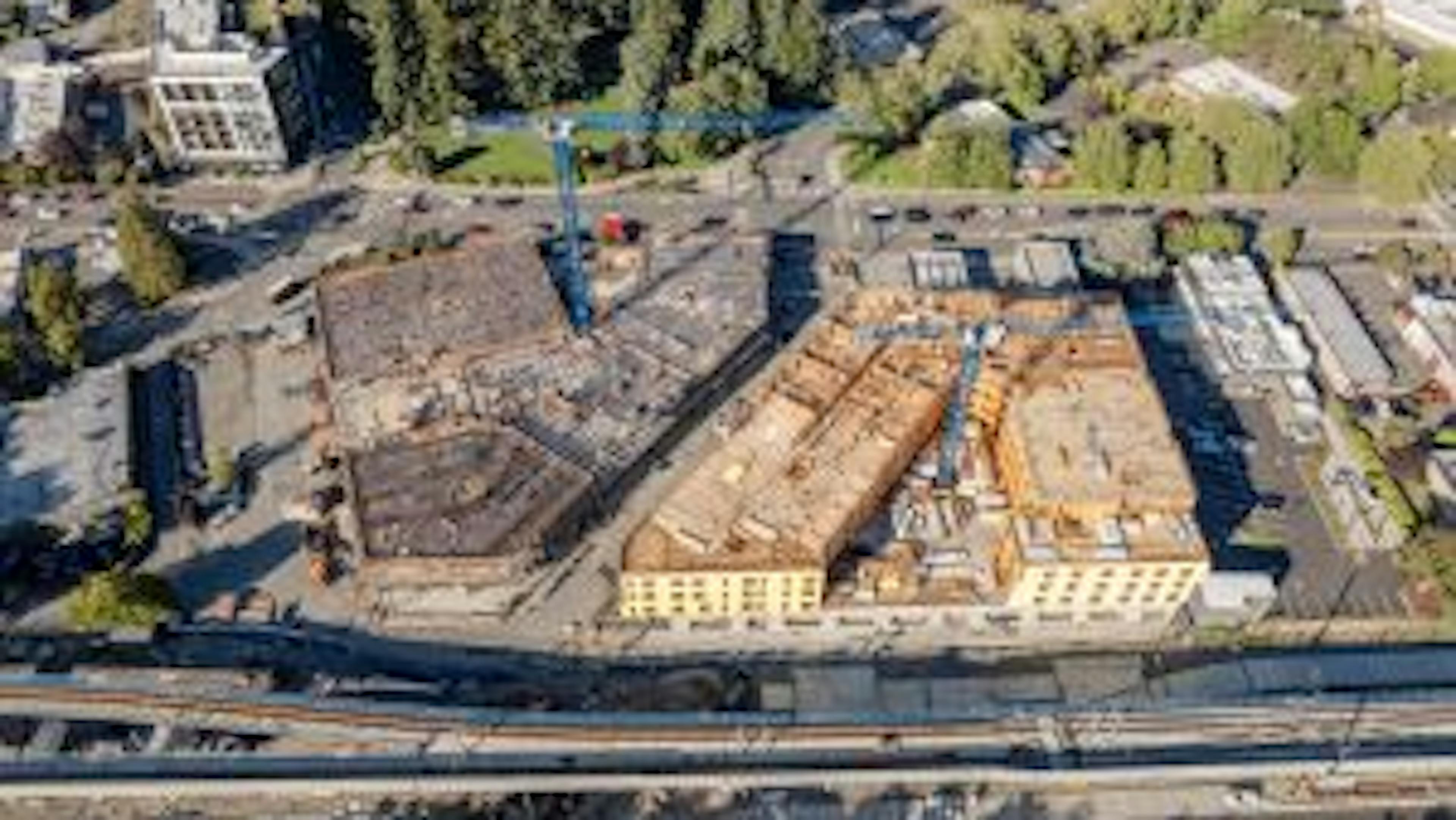 Aerial view of AMLI Redmond Way site with two blue cranes rising above two buildings under construction