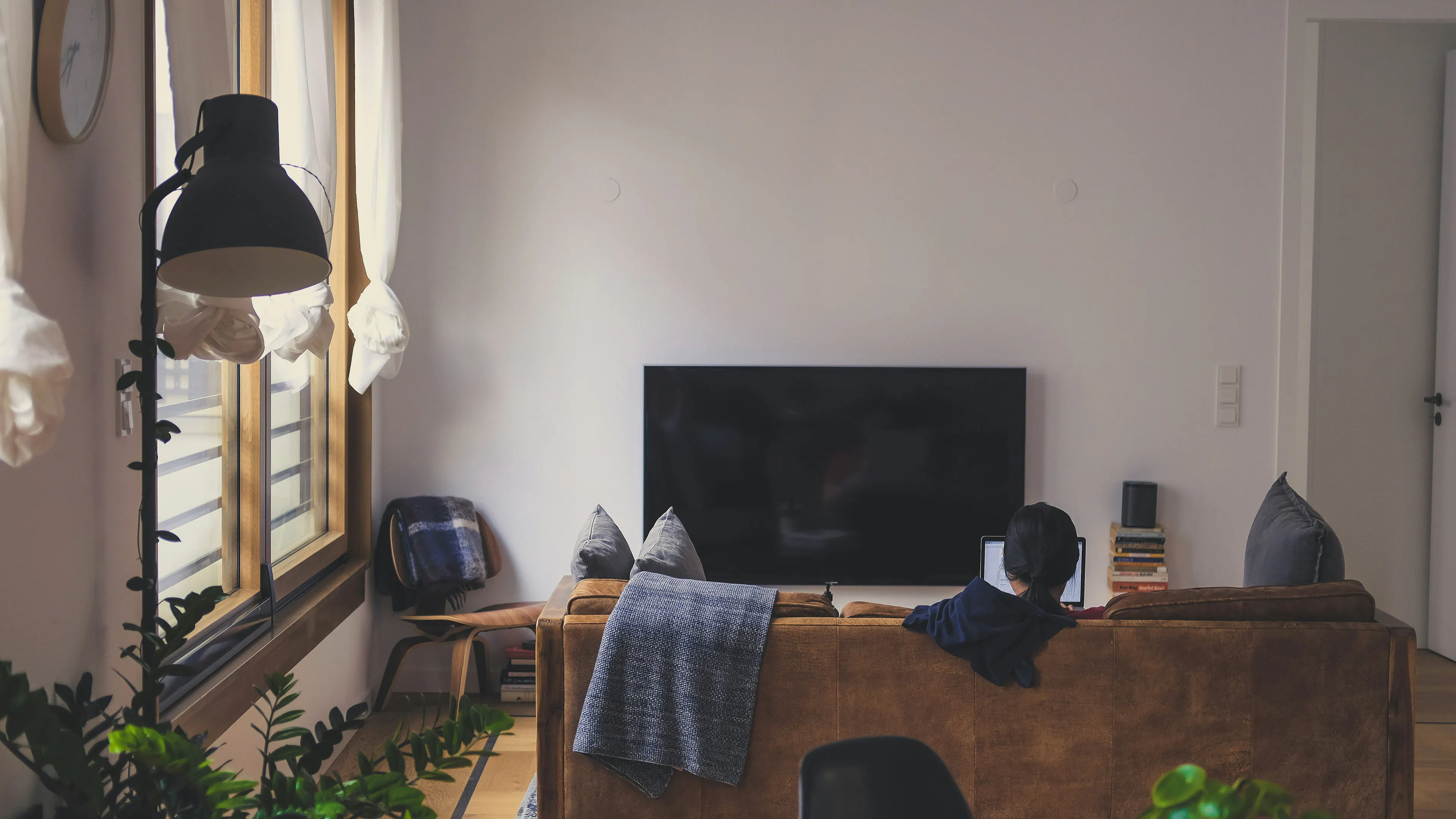 woman sitting on couch in front of LED TV