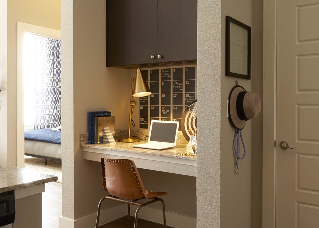 View from kitchen at AMLI on Riverside with a built in desk with brown cabinets overhead next to a closet and entry to bedroom