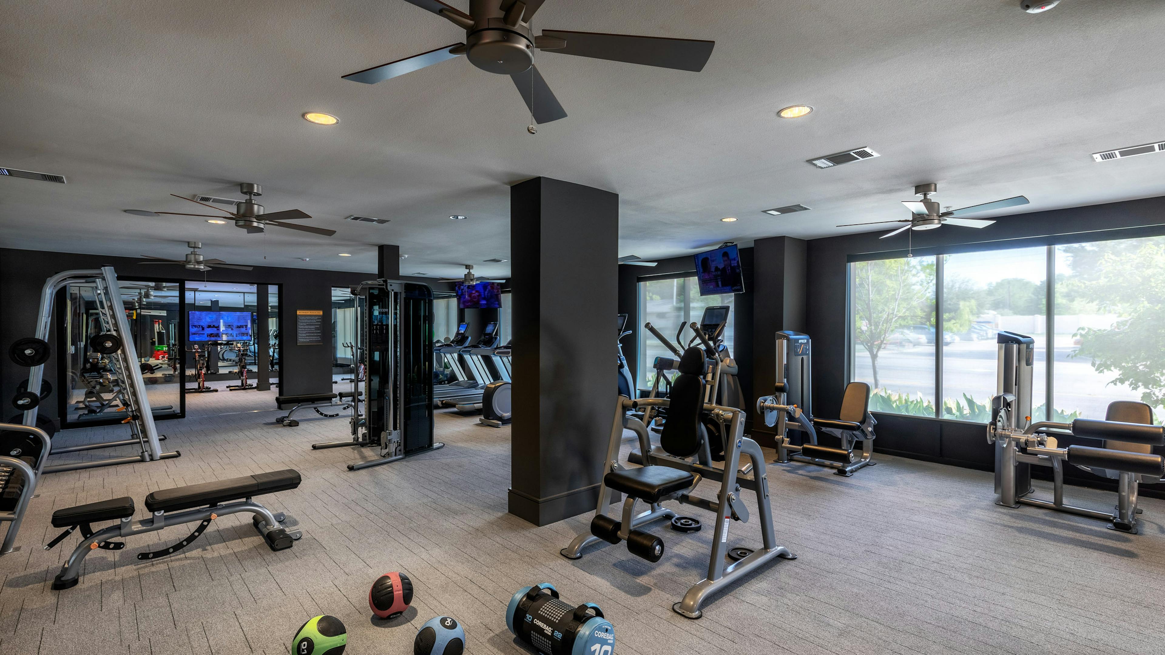 Interior view of AMLI Grapevine fitness center boasting TVs and free weights and strength training and and cardio machines 