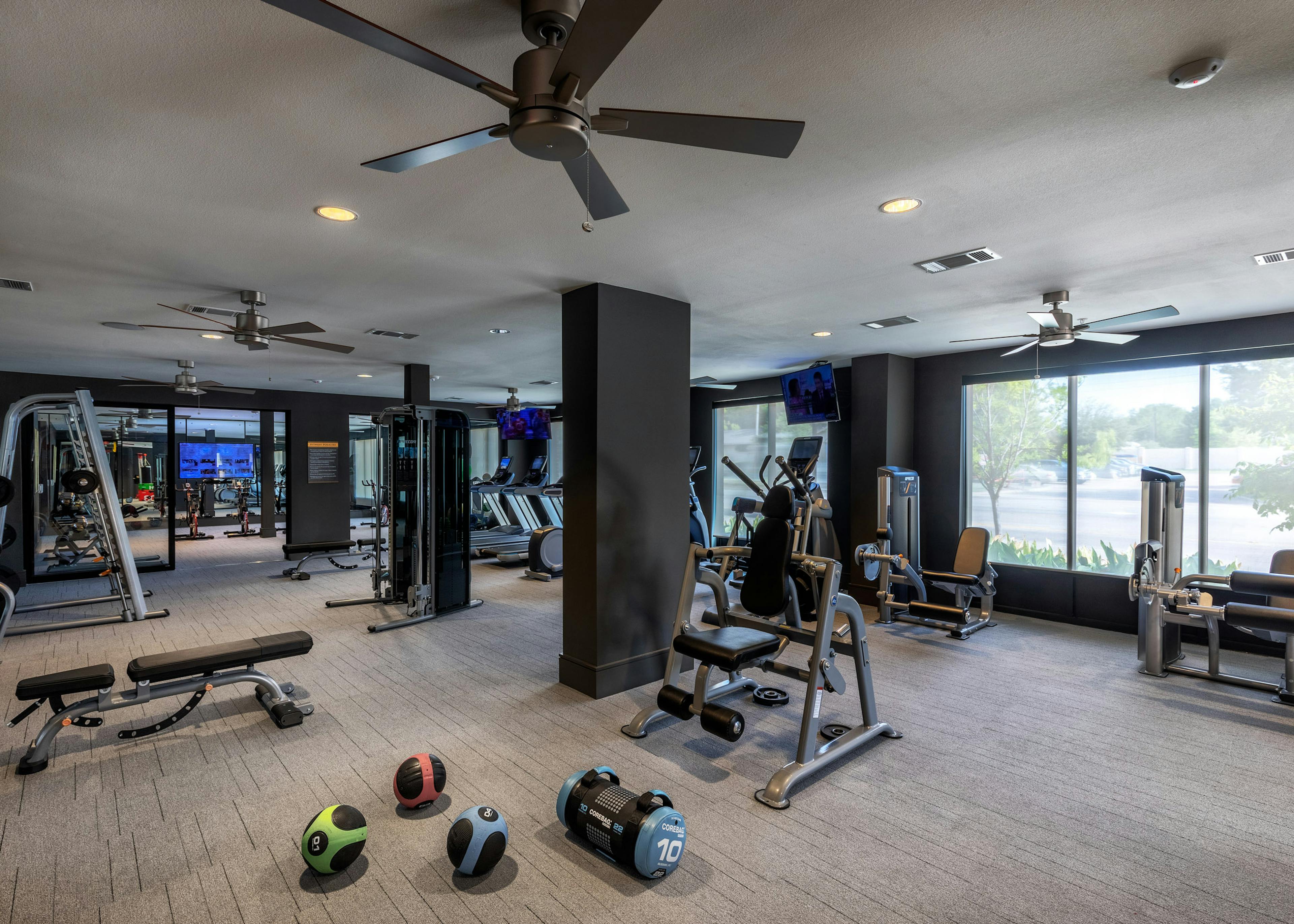 Interior view of AMLI Grapevine fitness center boasting TVs and free weights and strength training and cardio machines 