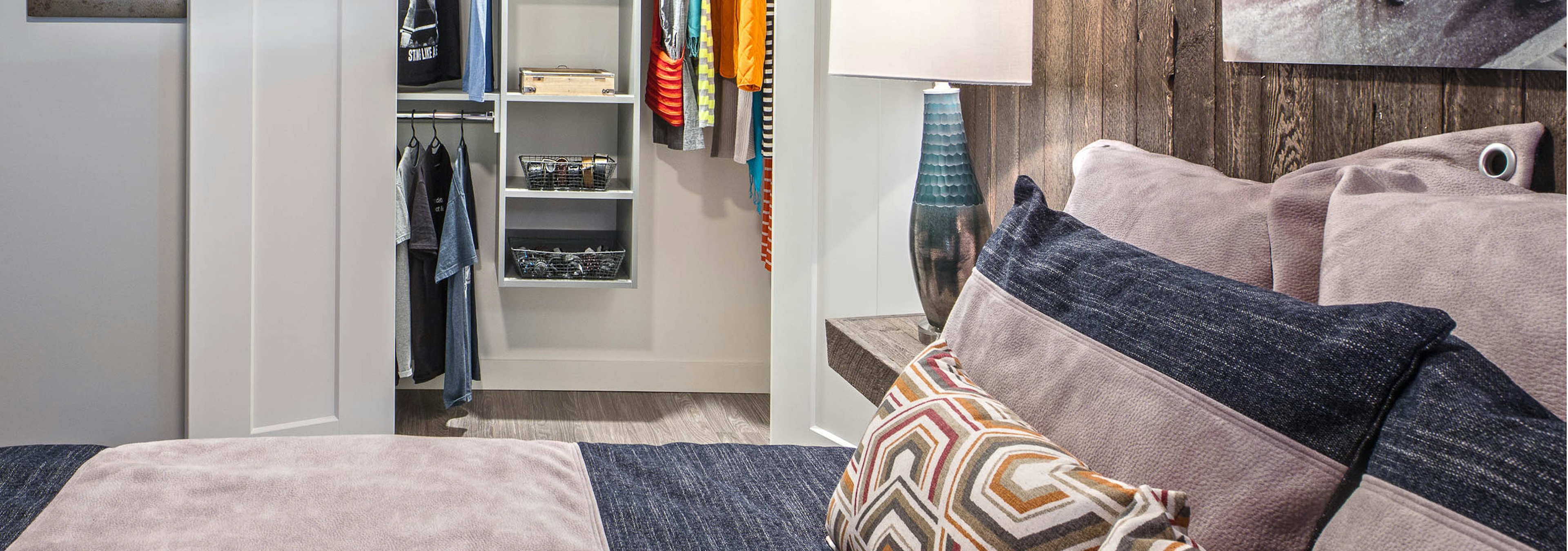 Interior view of apartment of AMLI Arc of bedroom with white walls room for a queen bed and walk-in California Closet