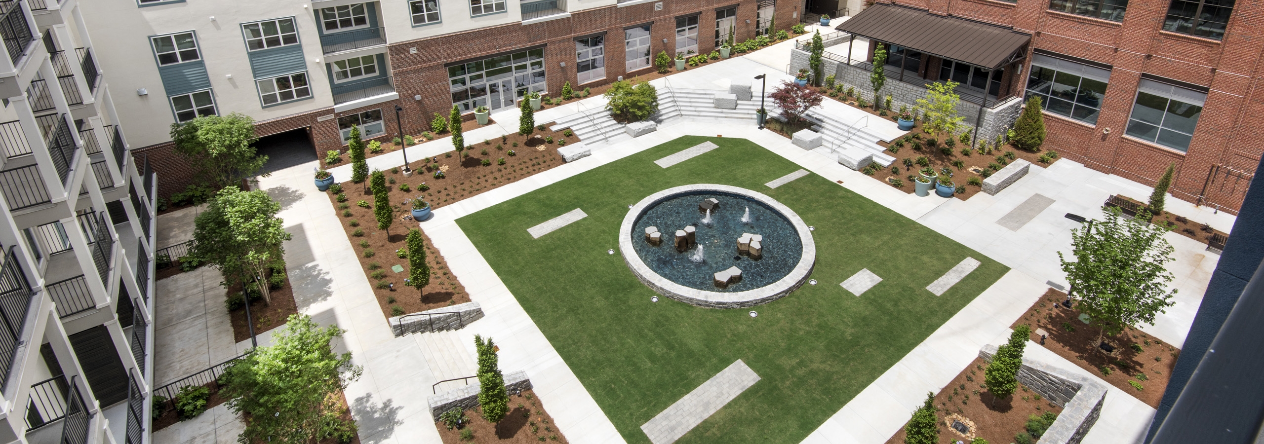 Aerial daytime view of the AMLI Decatur grassy and landscaped courtyard encircled by the apartment and office buildings