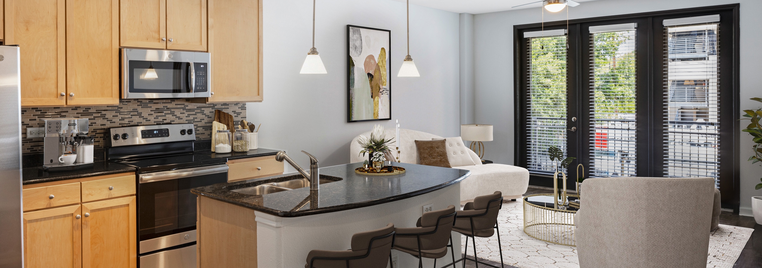 AMLI 300 apartment kitchen with light wood cabinets with black granite countertops and living room with white couch and chairs