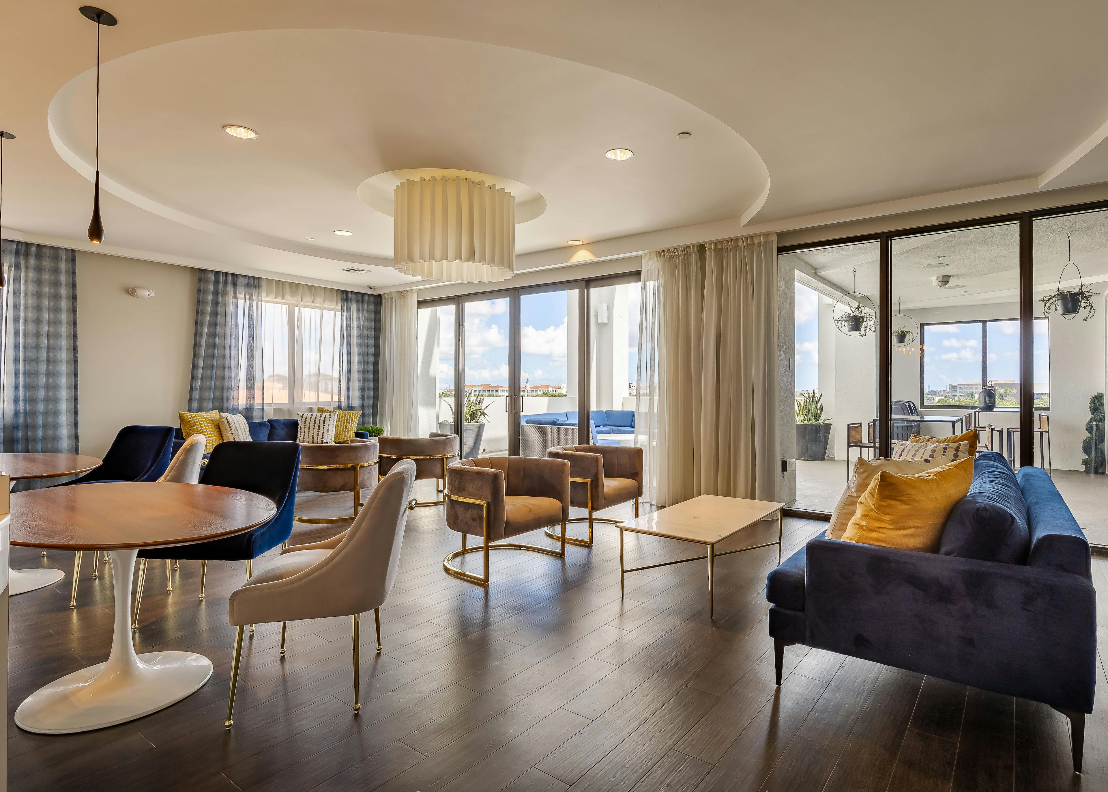 AMLI 8800 apartment resident sky lounge with dark wood floors and contemporary seating with floor to ceiling windows 